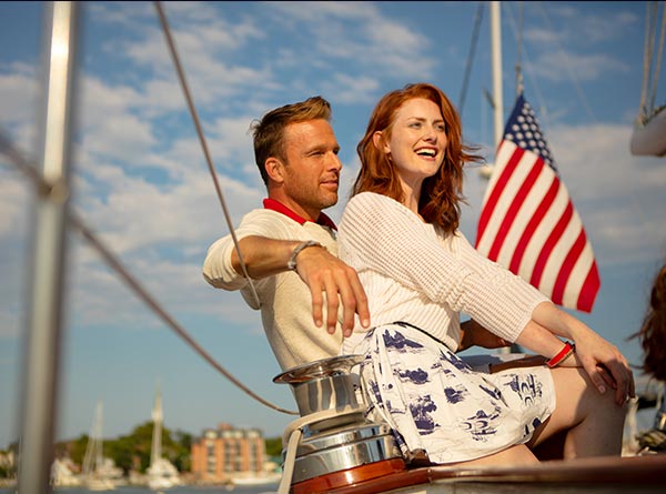 Young couple enjoying sail in blue skies and sun