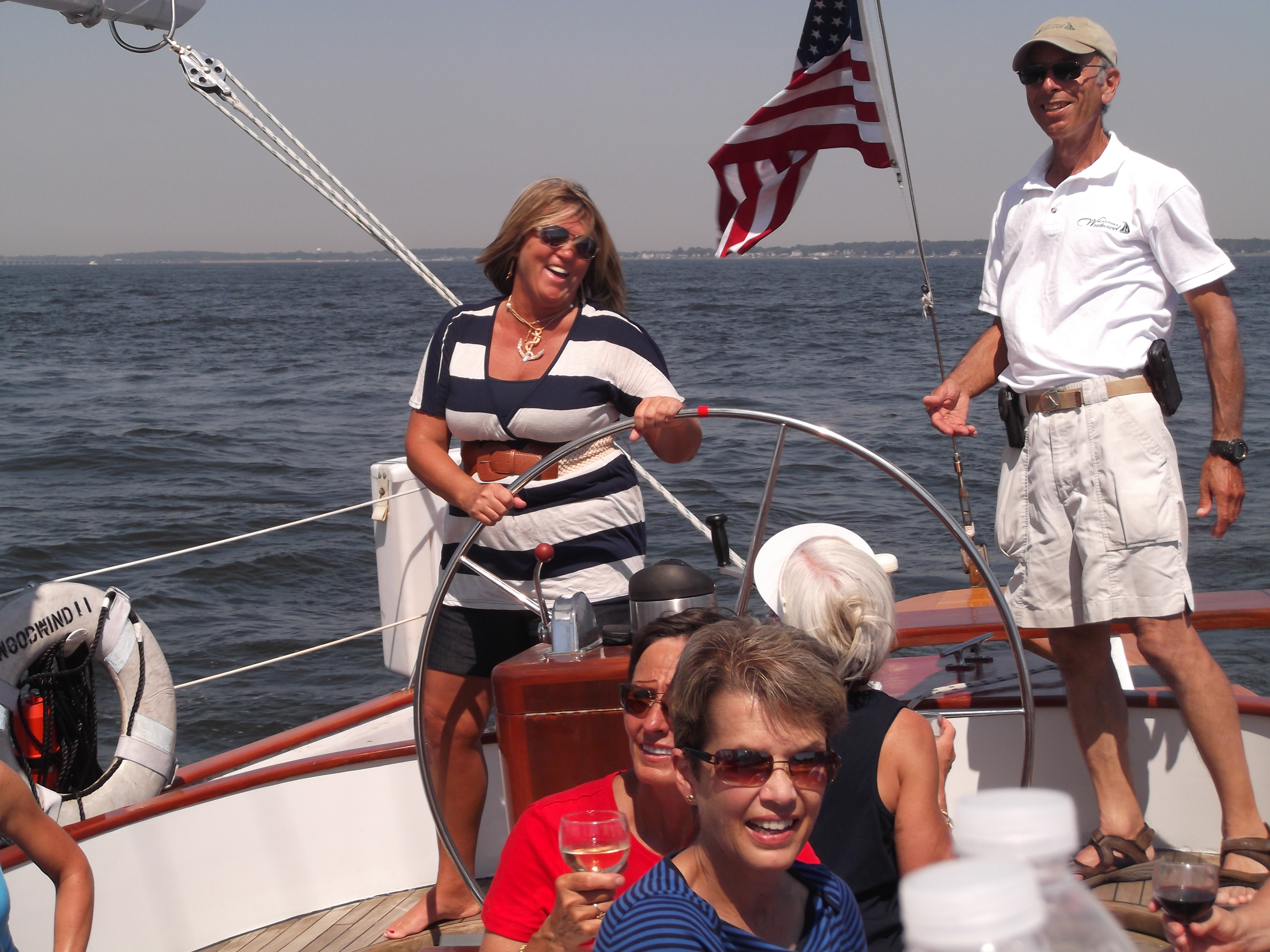 Women in stripped dress at the helm with Captain Ken