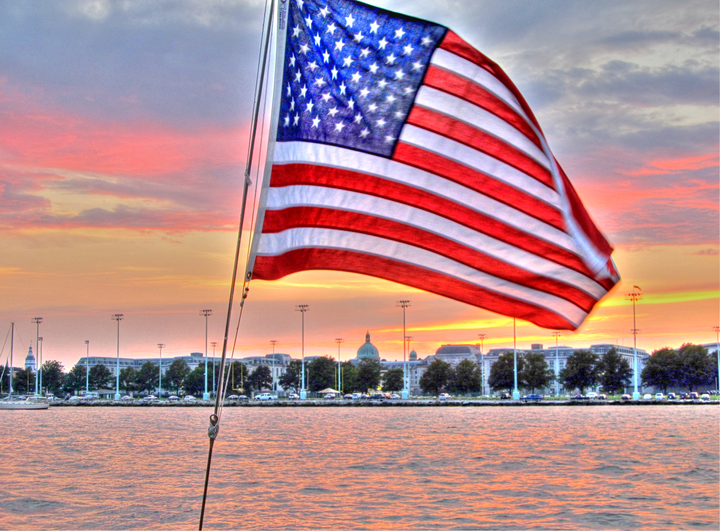 American flag from the Schooner with sunset and Naval Academy behind it