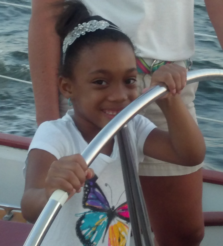 Little girl sailing the schooner with a butterfly shirt and a big smile