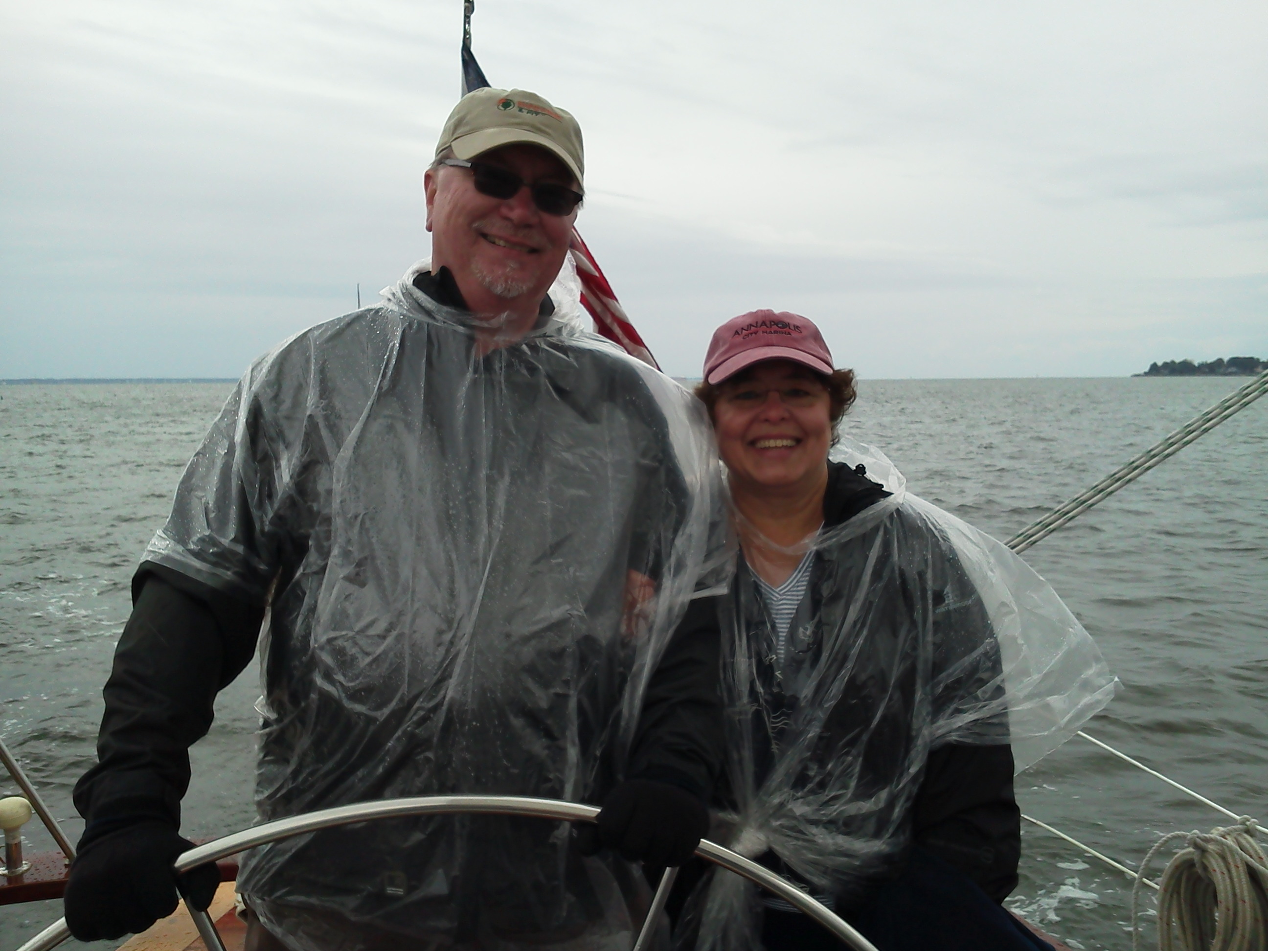 Fred and Jody Krazeise at the helm of Woodwind in clear ponchos