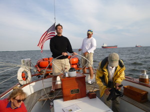 Andy checks main trim as our guest takes the helm.