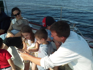 Frank reading to the kids aboard Woodwind about the different sailboats on the Bay.