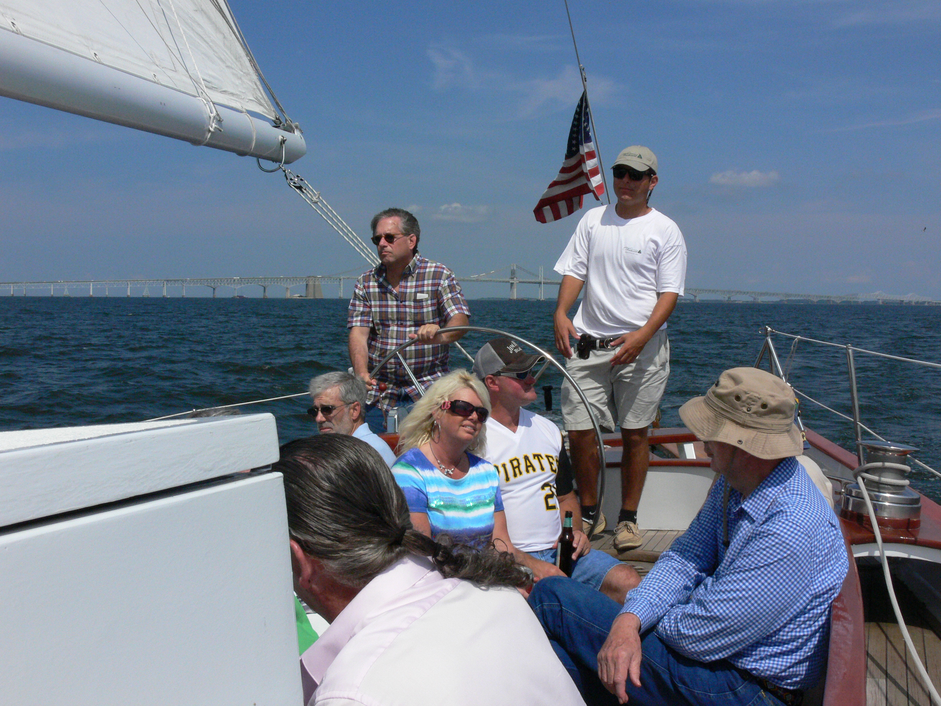 Guest steering the schooner with captain looking on