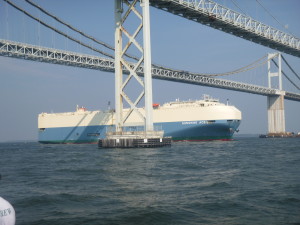 Car carrier going under the bridge.