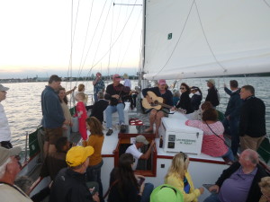 A boat load of people cheering on the Eastport Oyster Boys