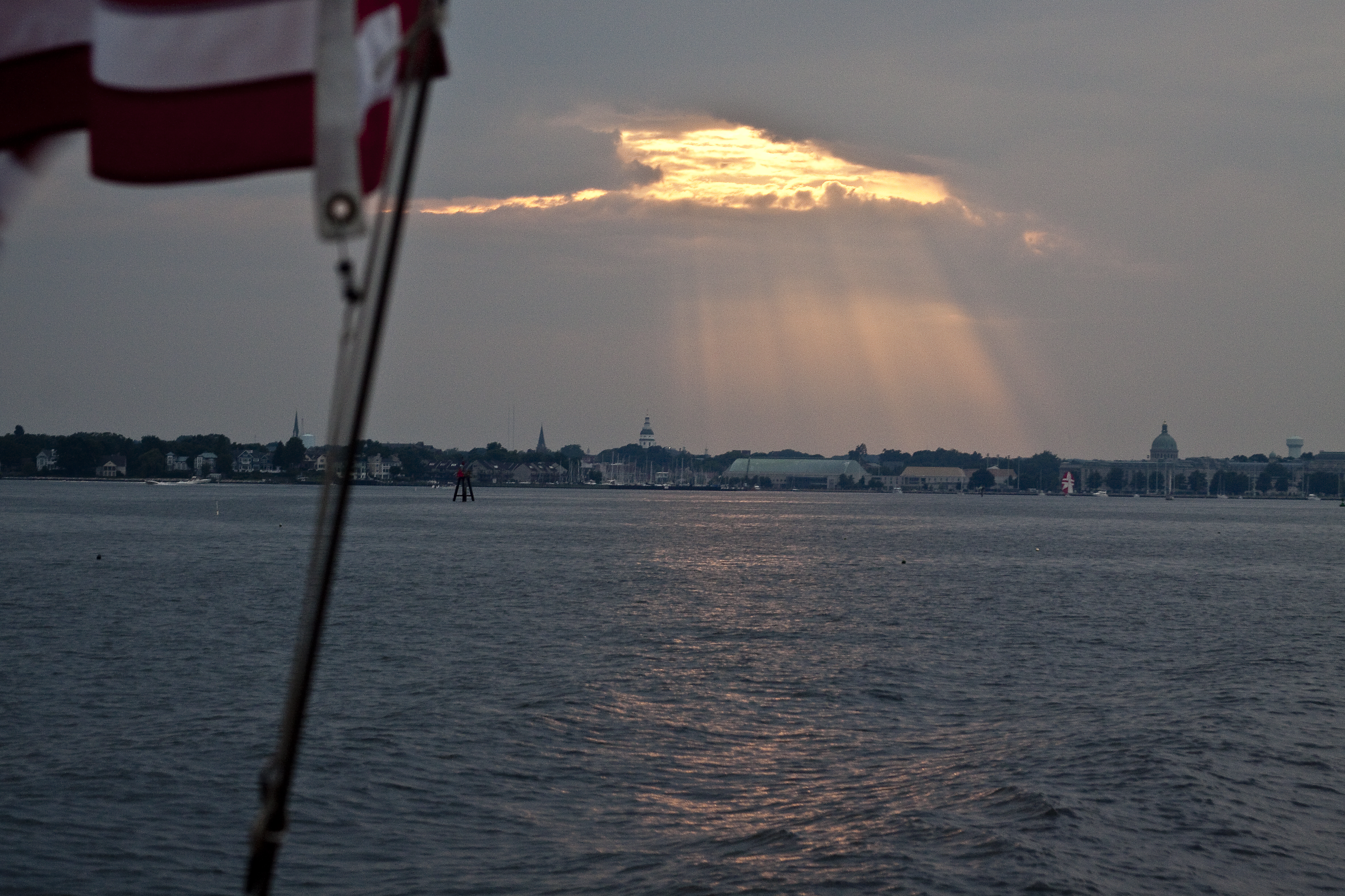 Sun rays shining over Annapolis taken from schooner on the water