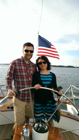 Couple with sunglasses on steering the schooner