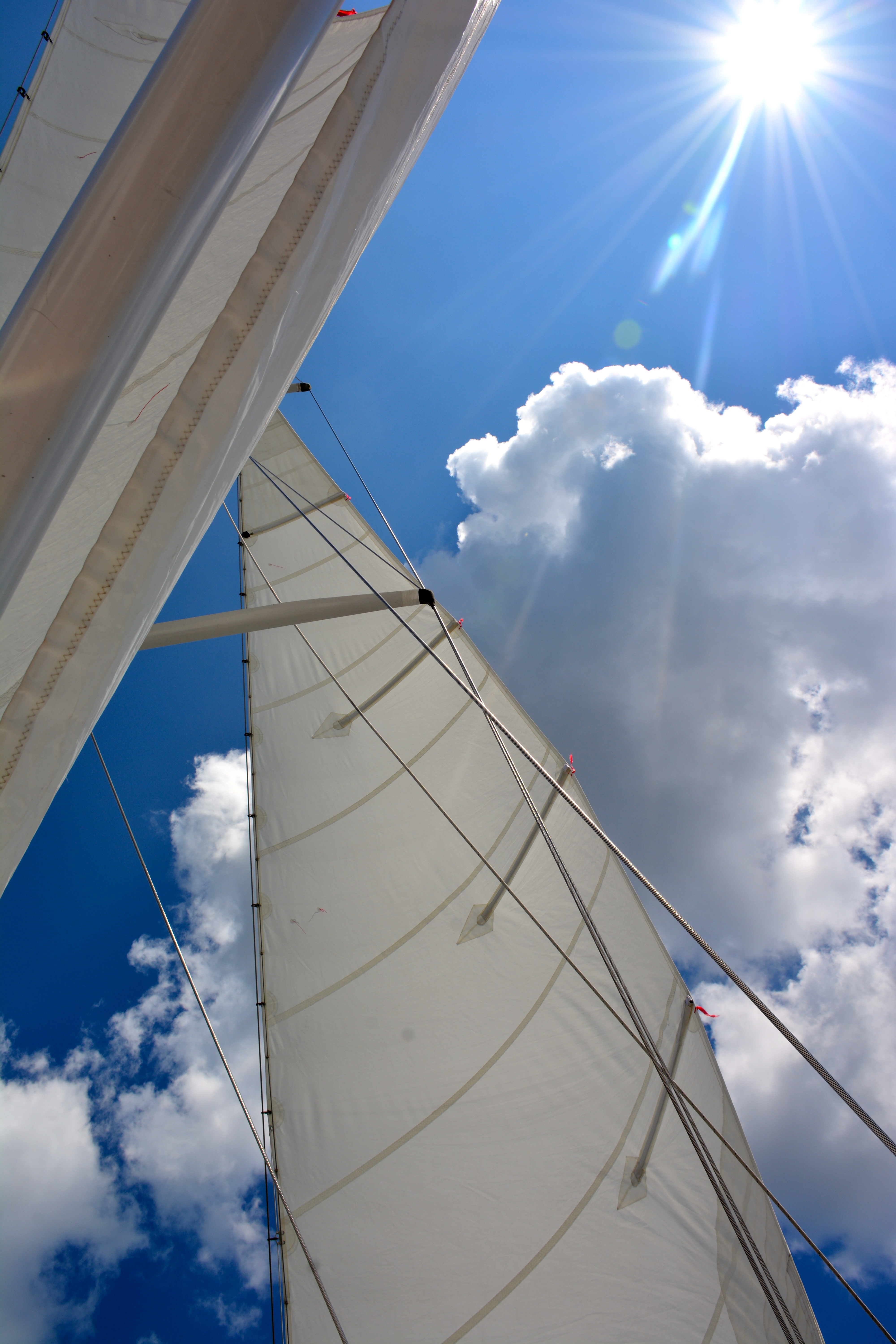 Sails, white clouds and blue skies