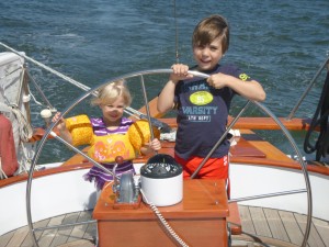 Wyatt and Caroline on the helm of the Schooner Woodwind