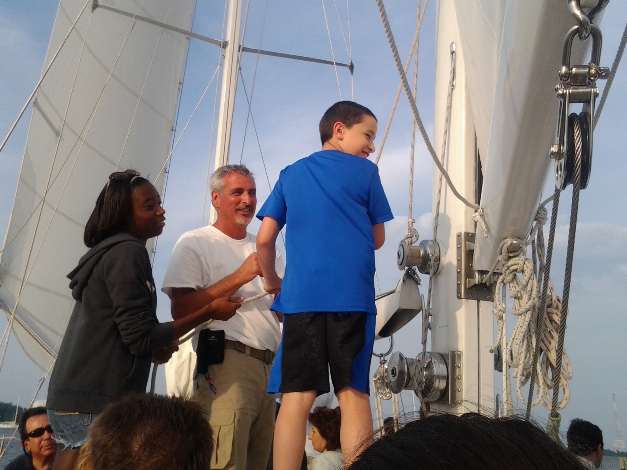 Young man laughing and helping with sails