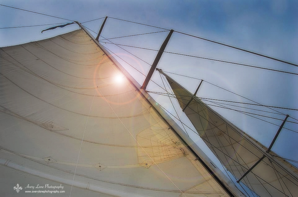Looking straight up the sails at a sunny blue sky
