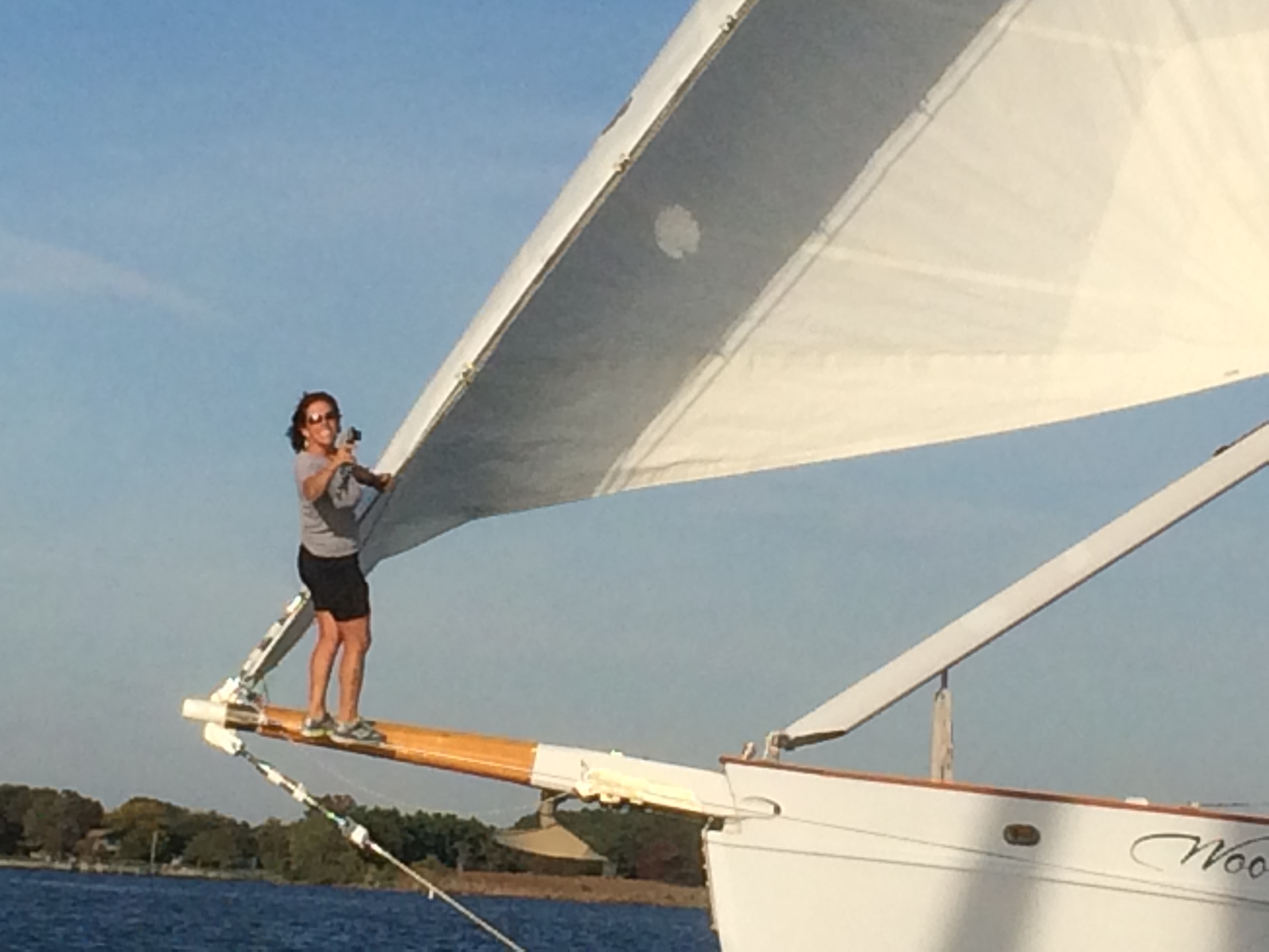 Captain Jen hanging onto the foremast and standing on the bowsprit