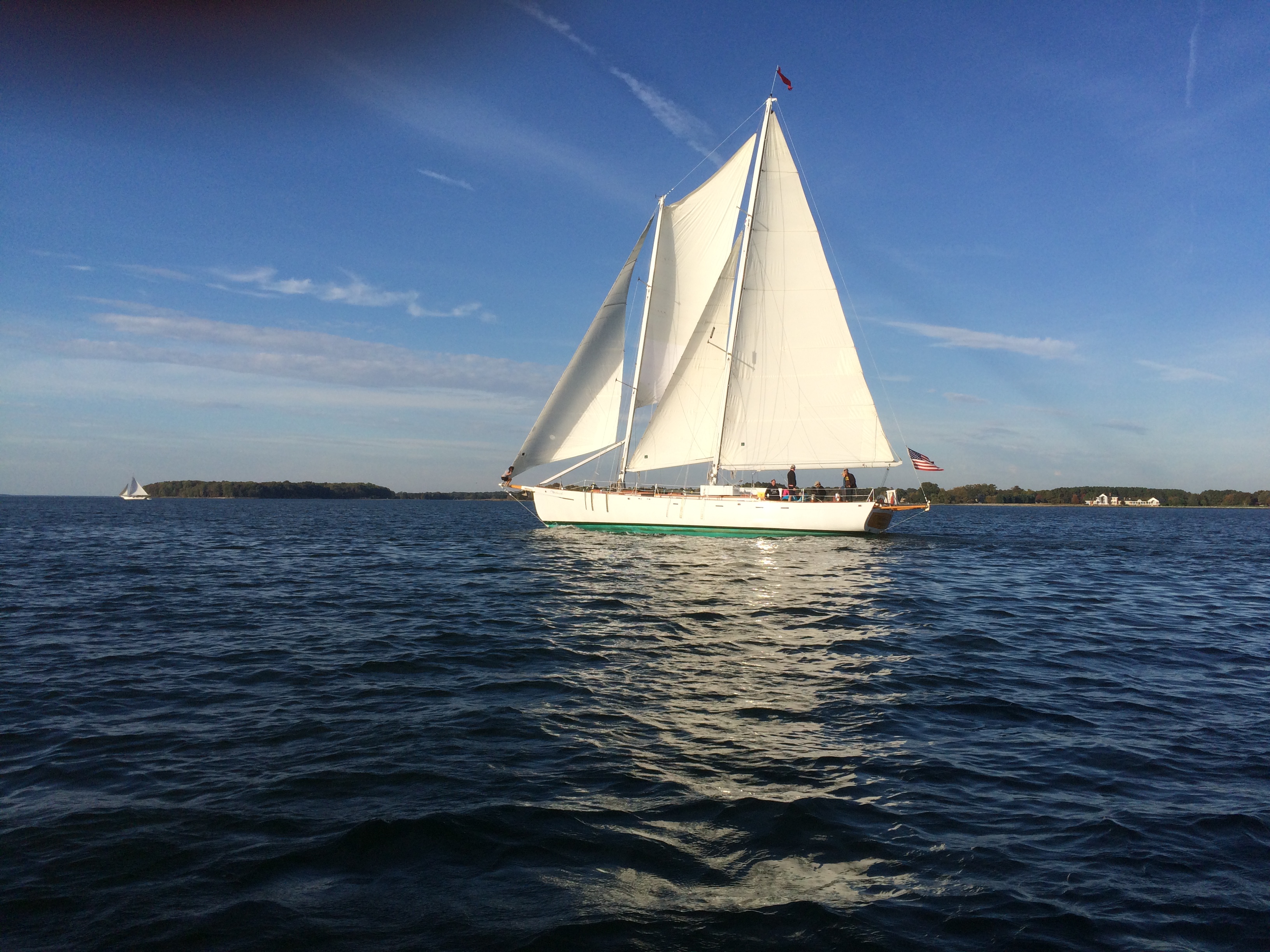 Schooner in full sail against a blue sky and blue waters