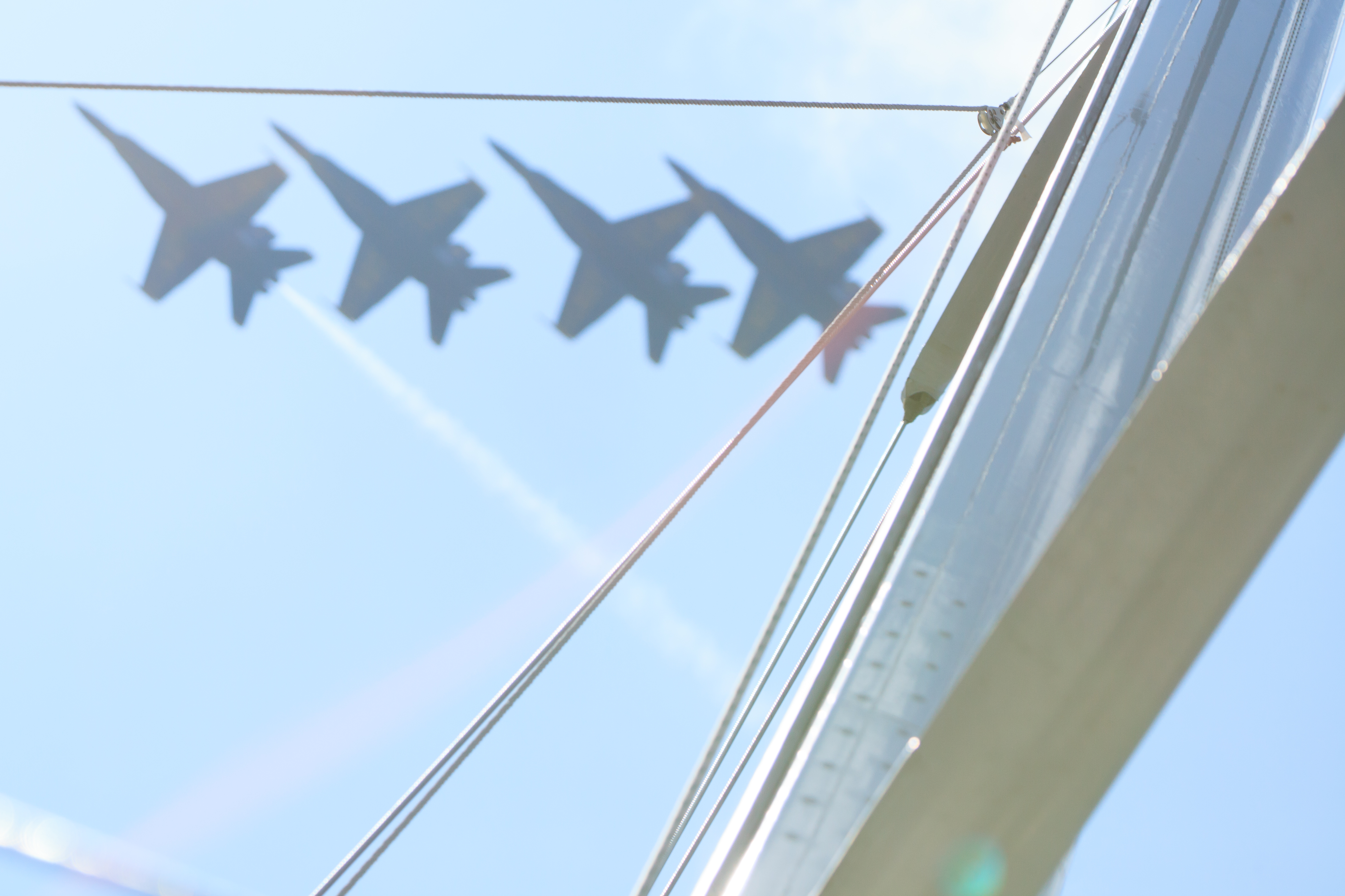 Blue Angels flying over sails of schooner in formation