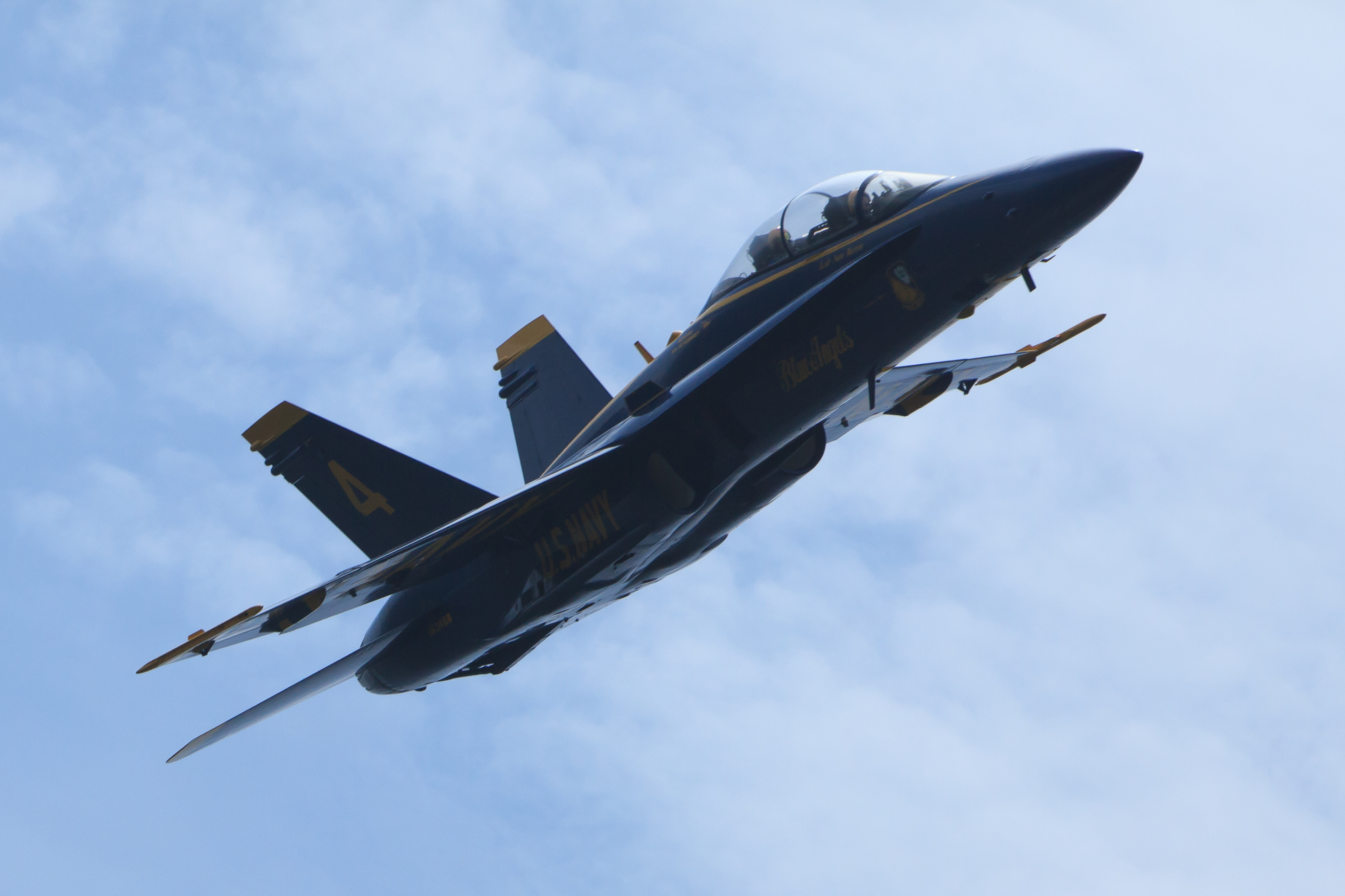 Close up picture of a Blue Angel Jet flying in a blue sky