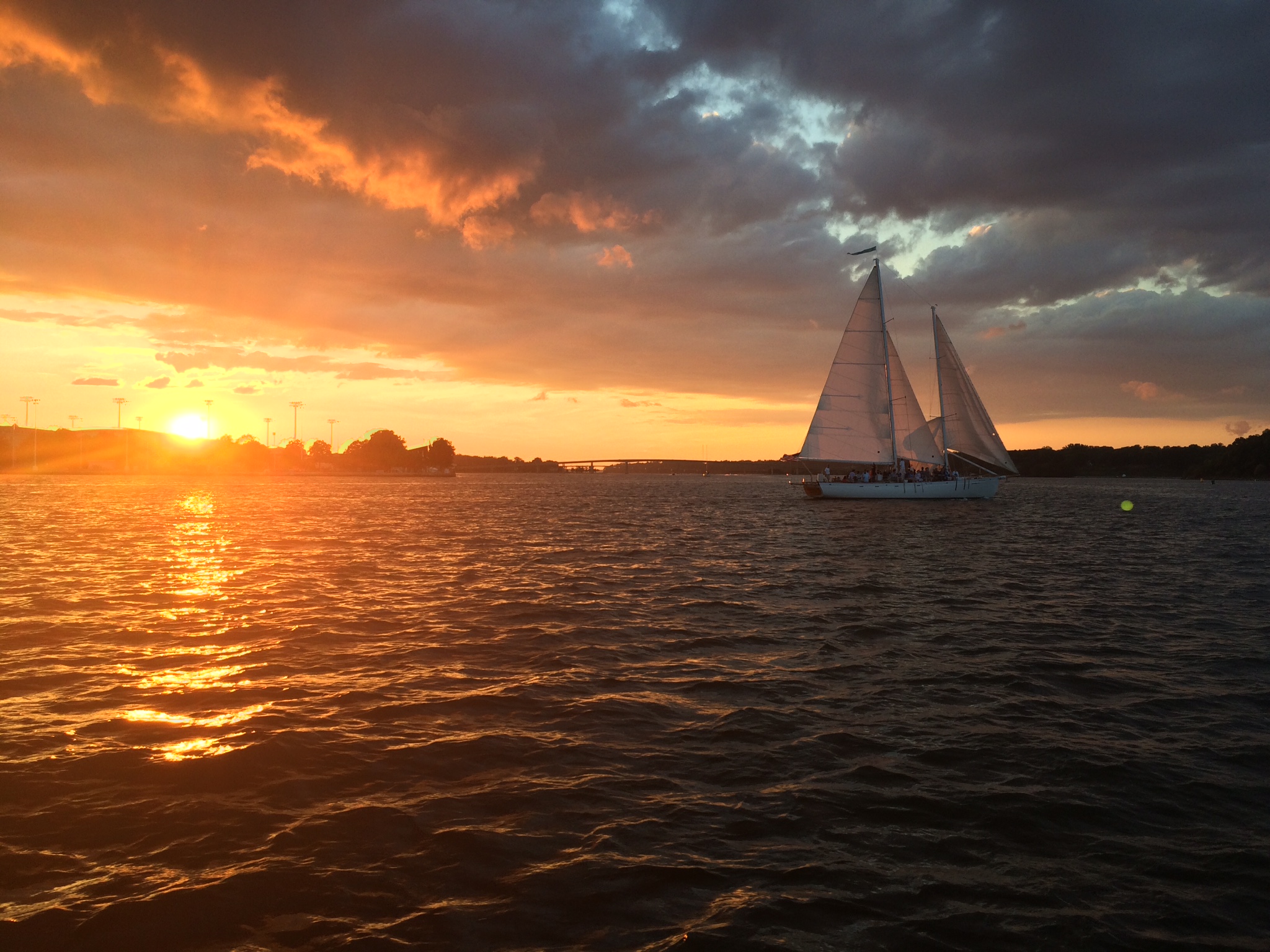 Sunset making everything glow orange with schooner sailing by