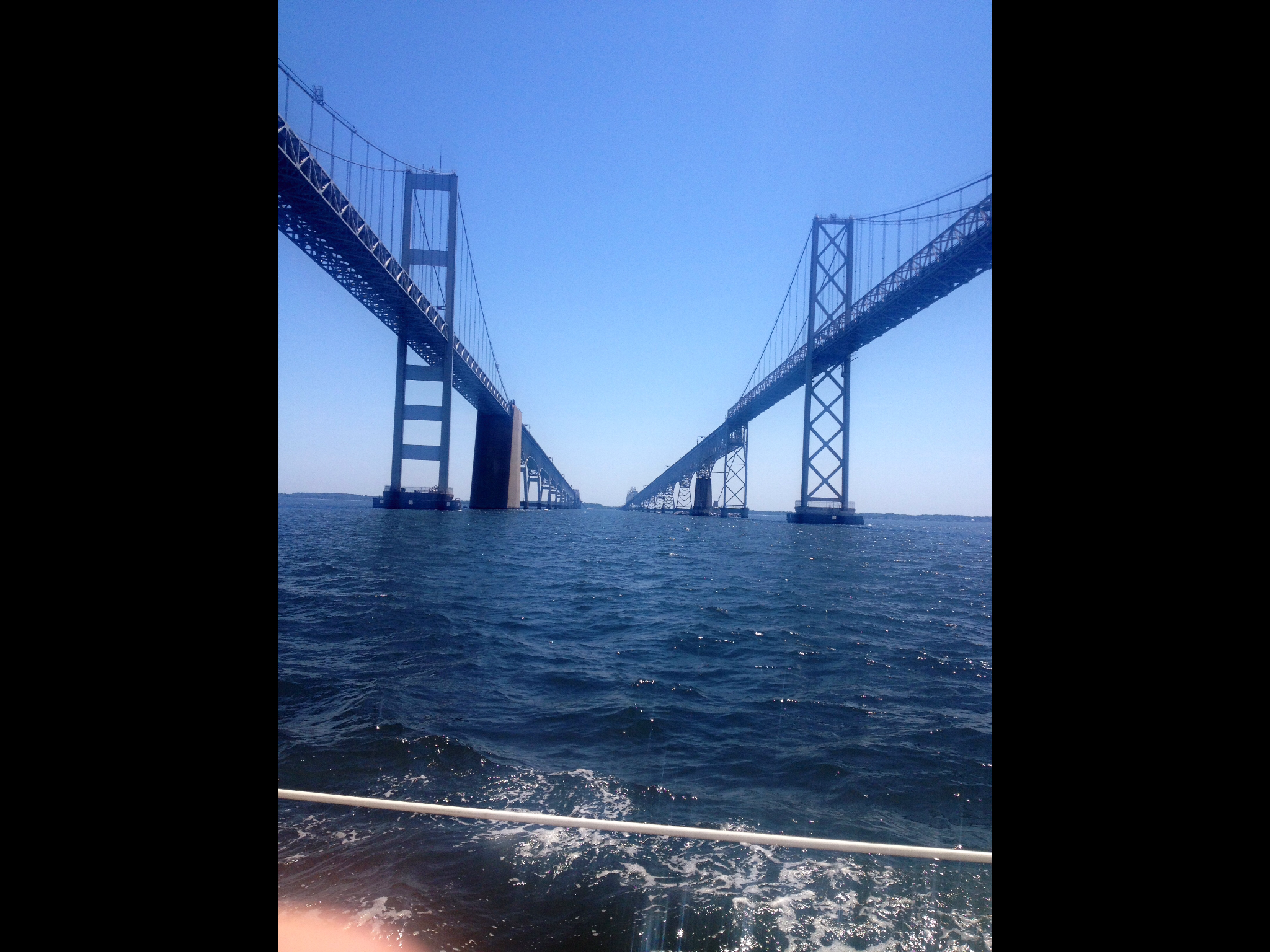 Sailing under the Bay Bridge on a sunny blue sky day