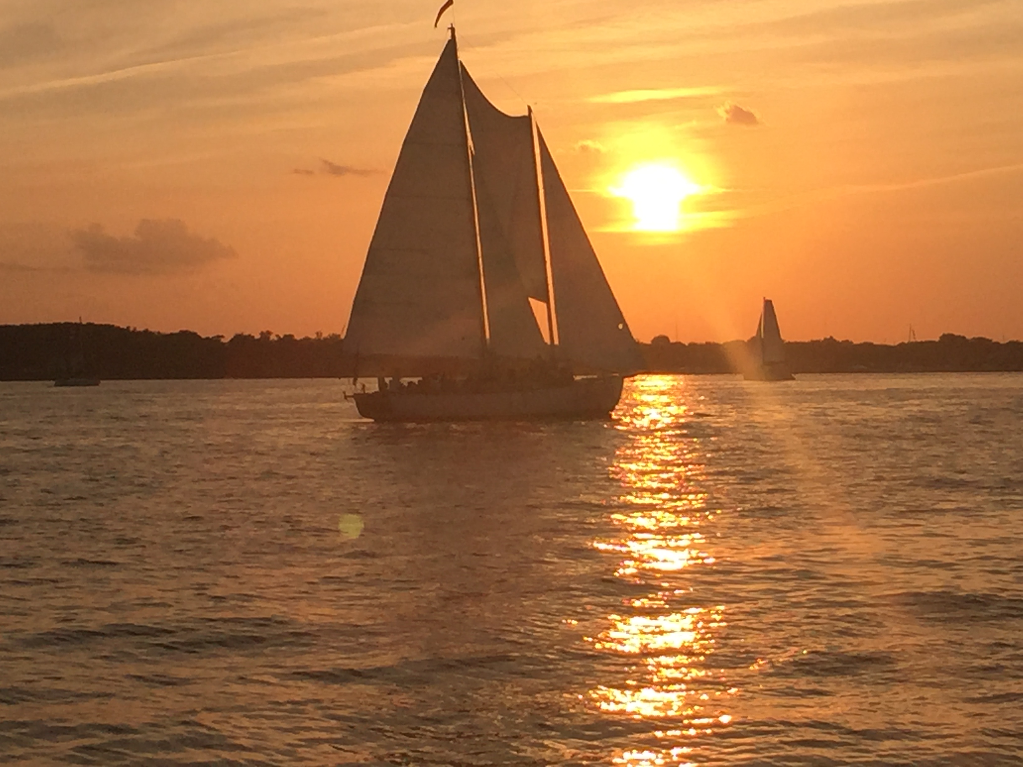 Beautiful sunset turning the sky and the water around the schooner gold