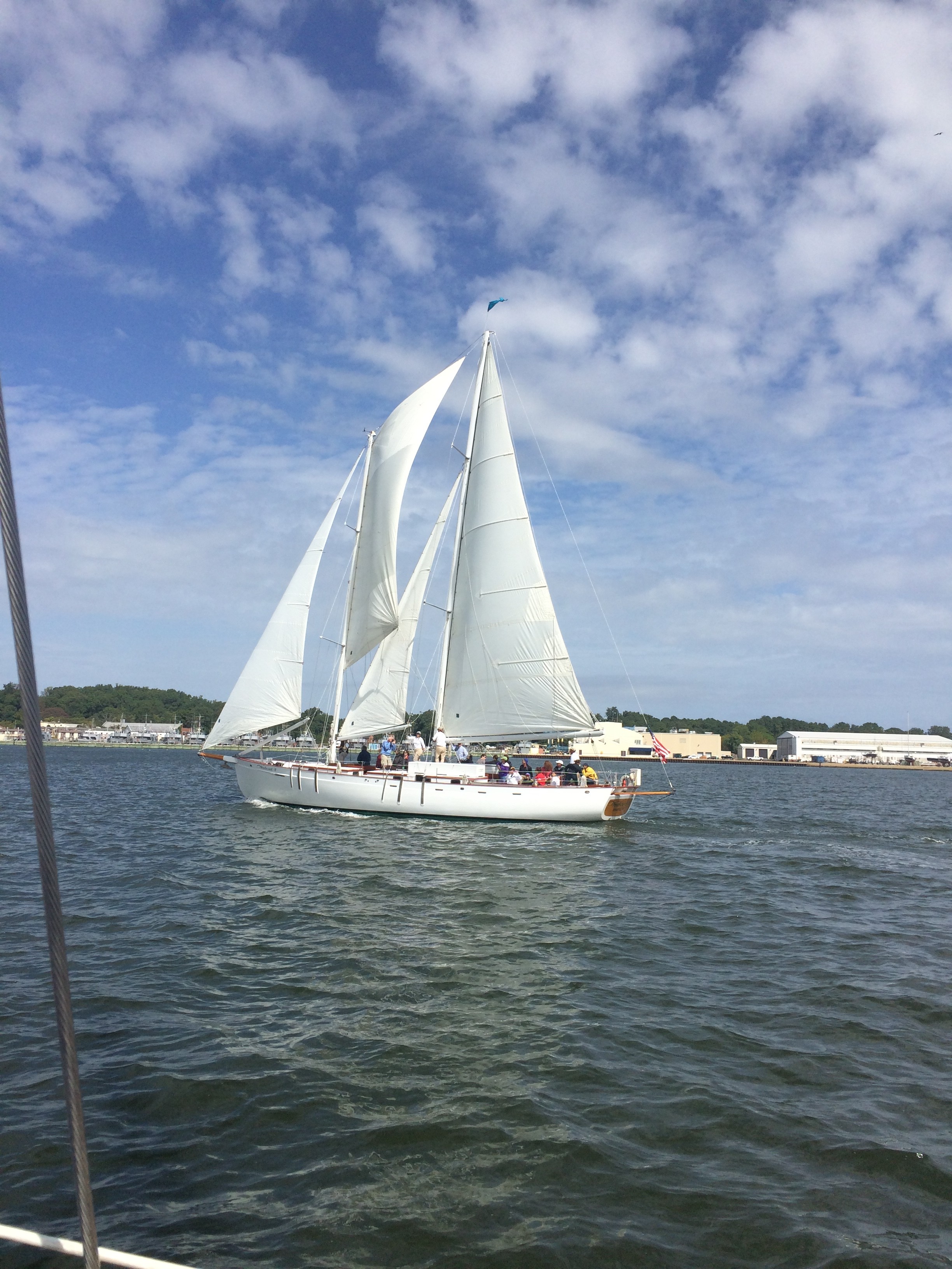 Schooner sailing on blue water with blue sky and white clouds