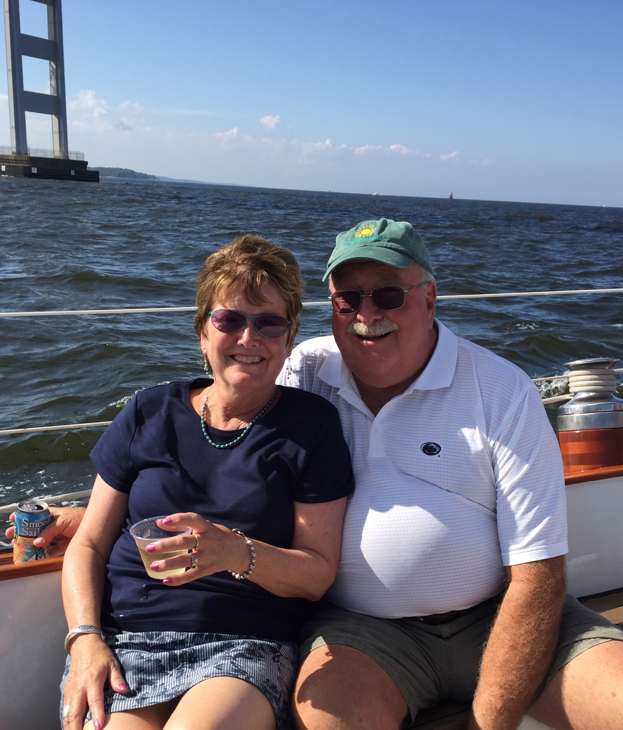 Man and women enjoying beverages while sailing under the bay bridge