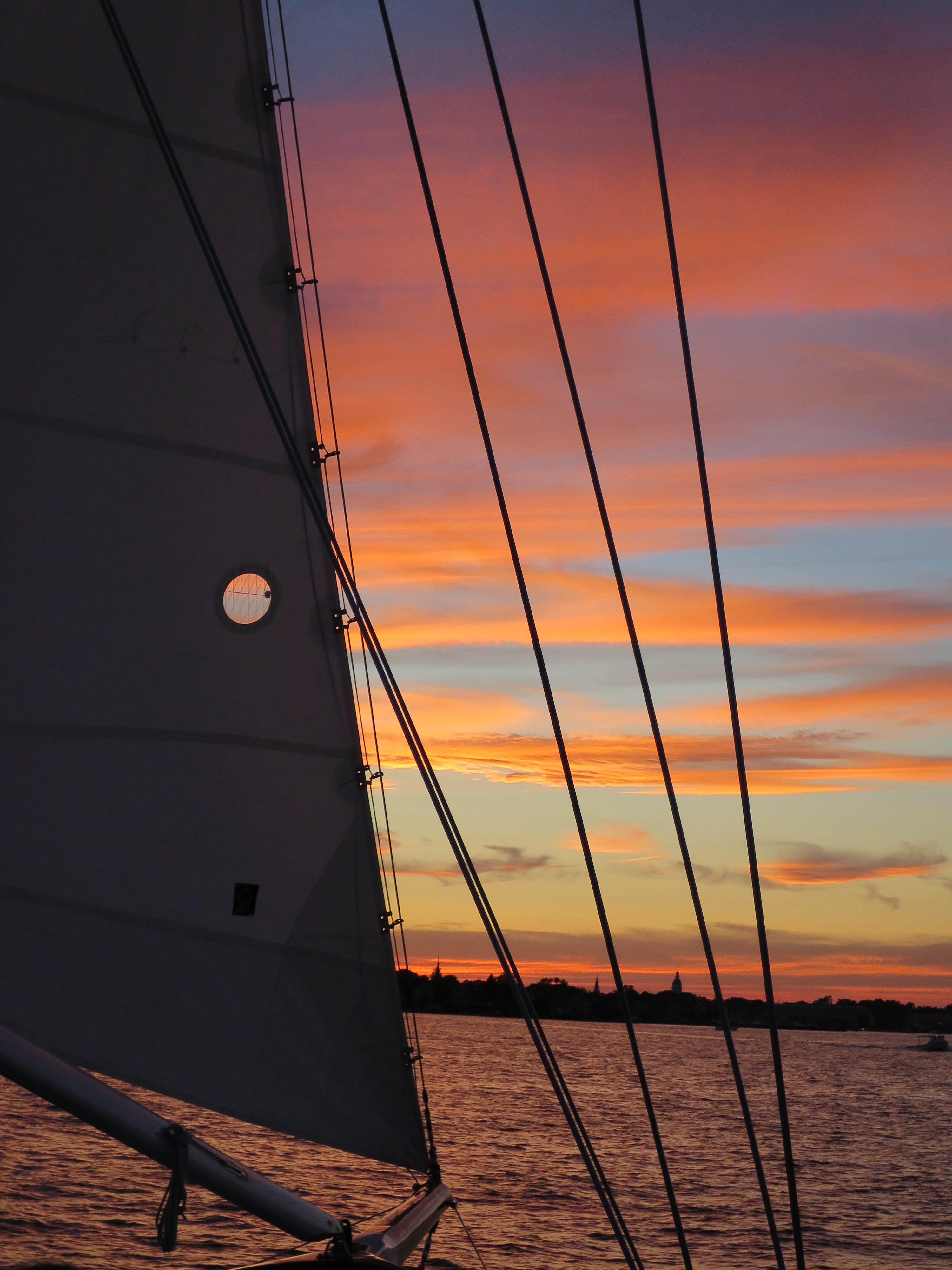 Streaked pink and blue sunset through the schooner sails