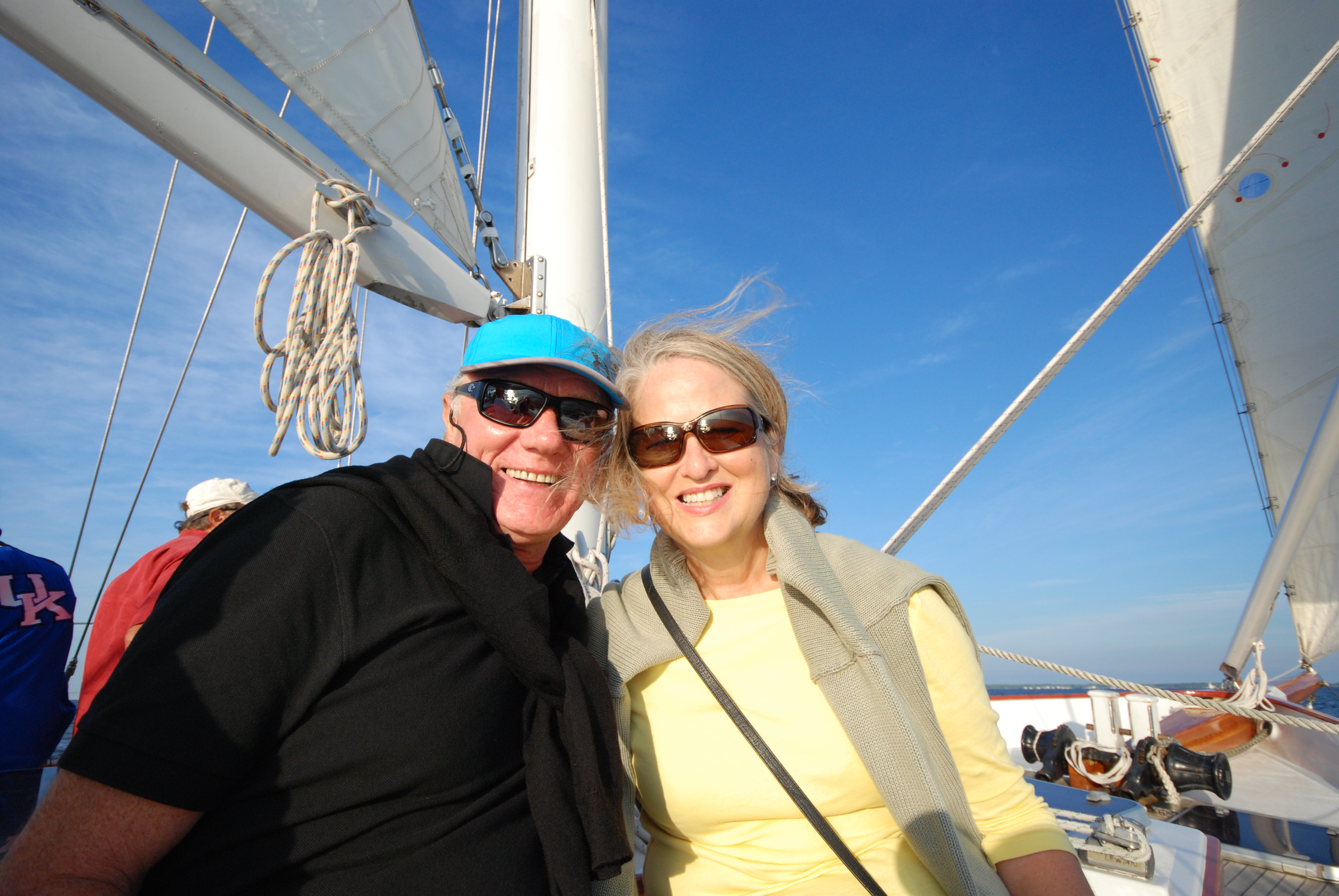 Man and women smiling on a sunny blue sky sail