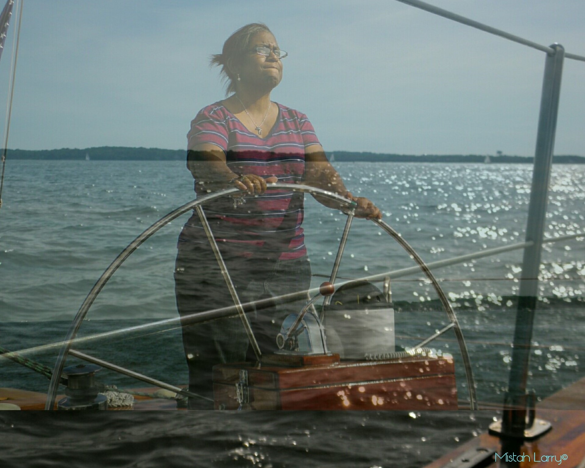 Women steering the schooner with water reflection all around her