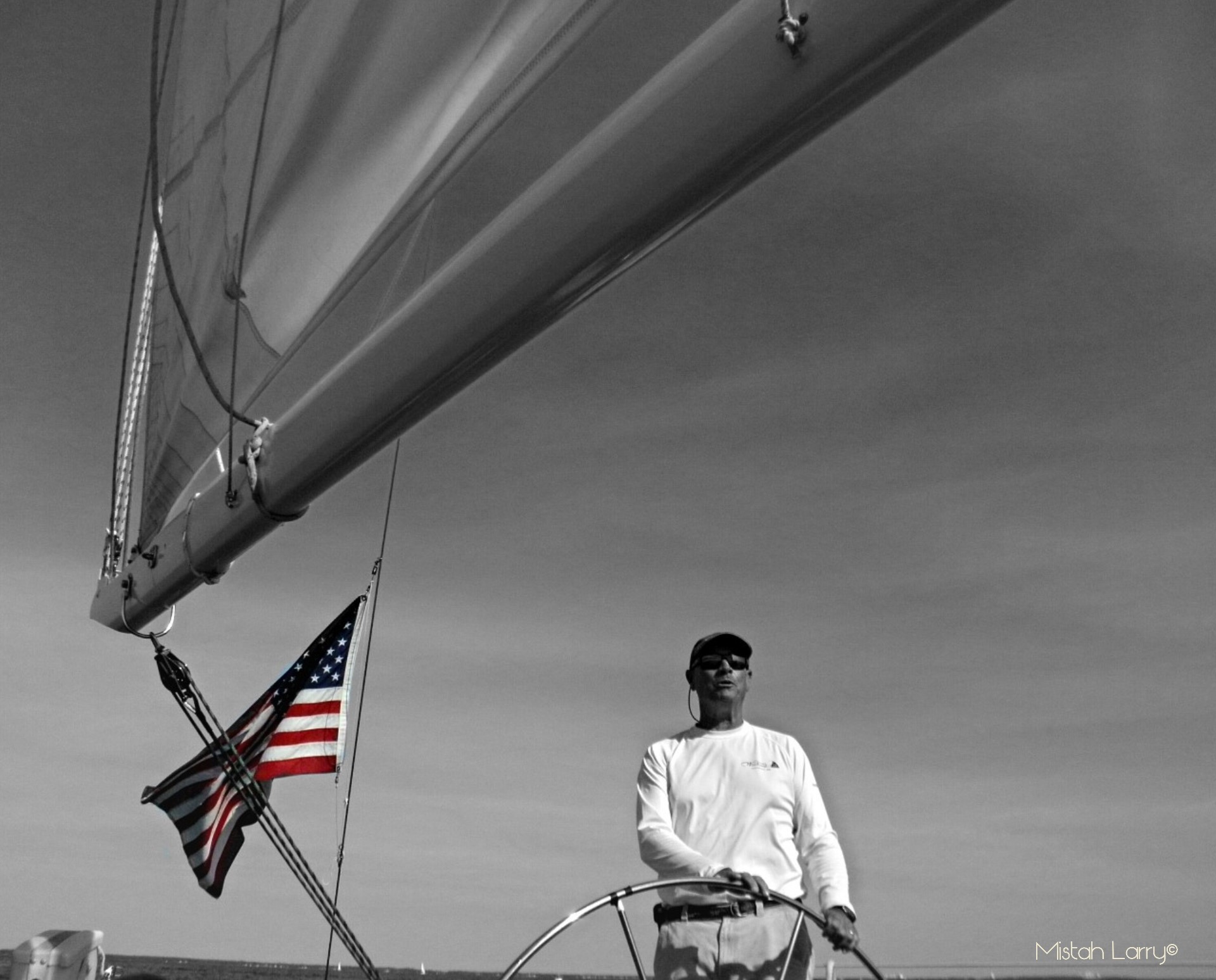 Black and white of captaining boat with a red white and blue flag