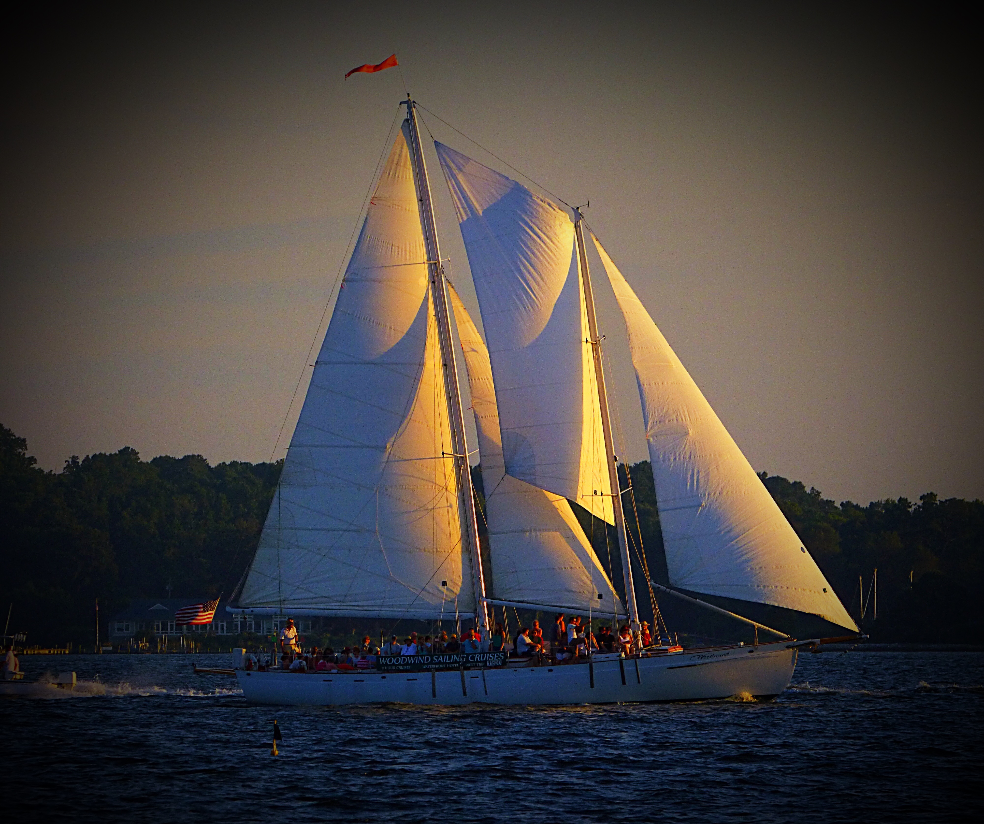 The schooner under full sail half in sunlight half in darkness