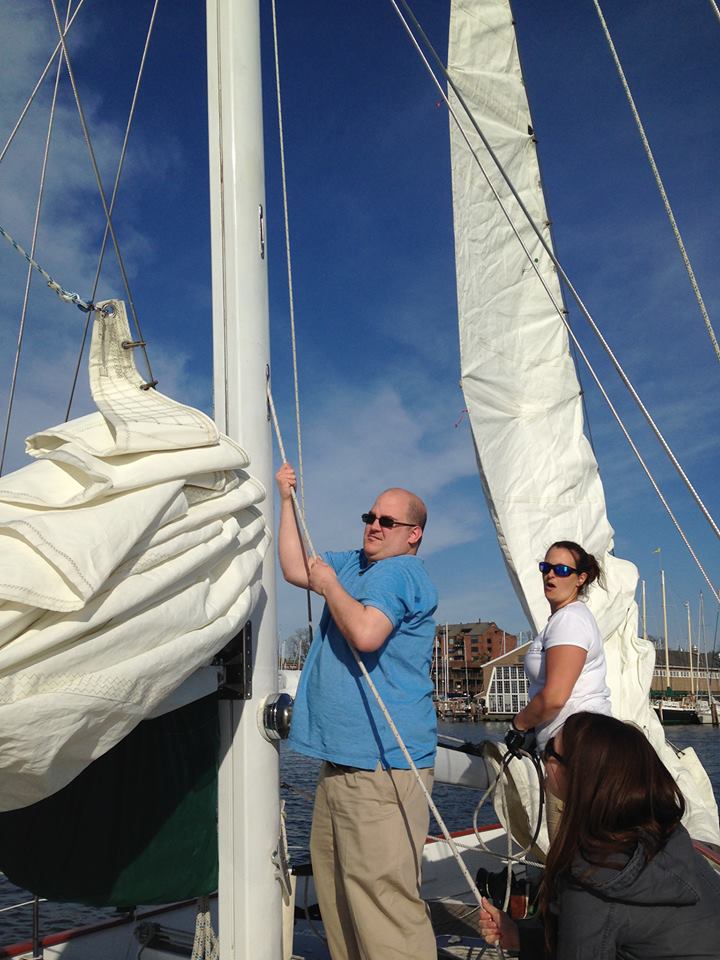 Guests lending a hand in raising the sails on board the schooner