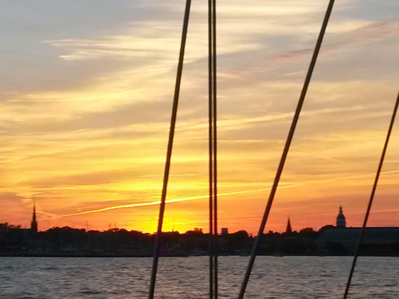 Orange streaked skyline silhouetting the Annapolis Capital through rigging