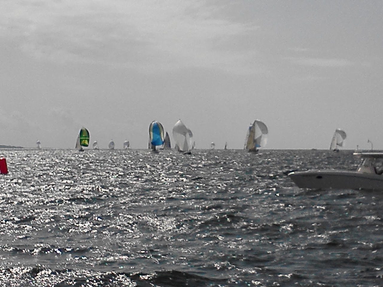 Sailboats with colorful Spinnaker Sails with sunlight sparkling on waves