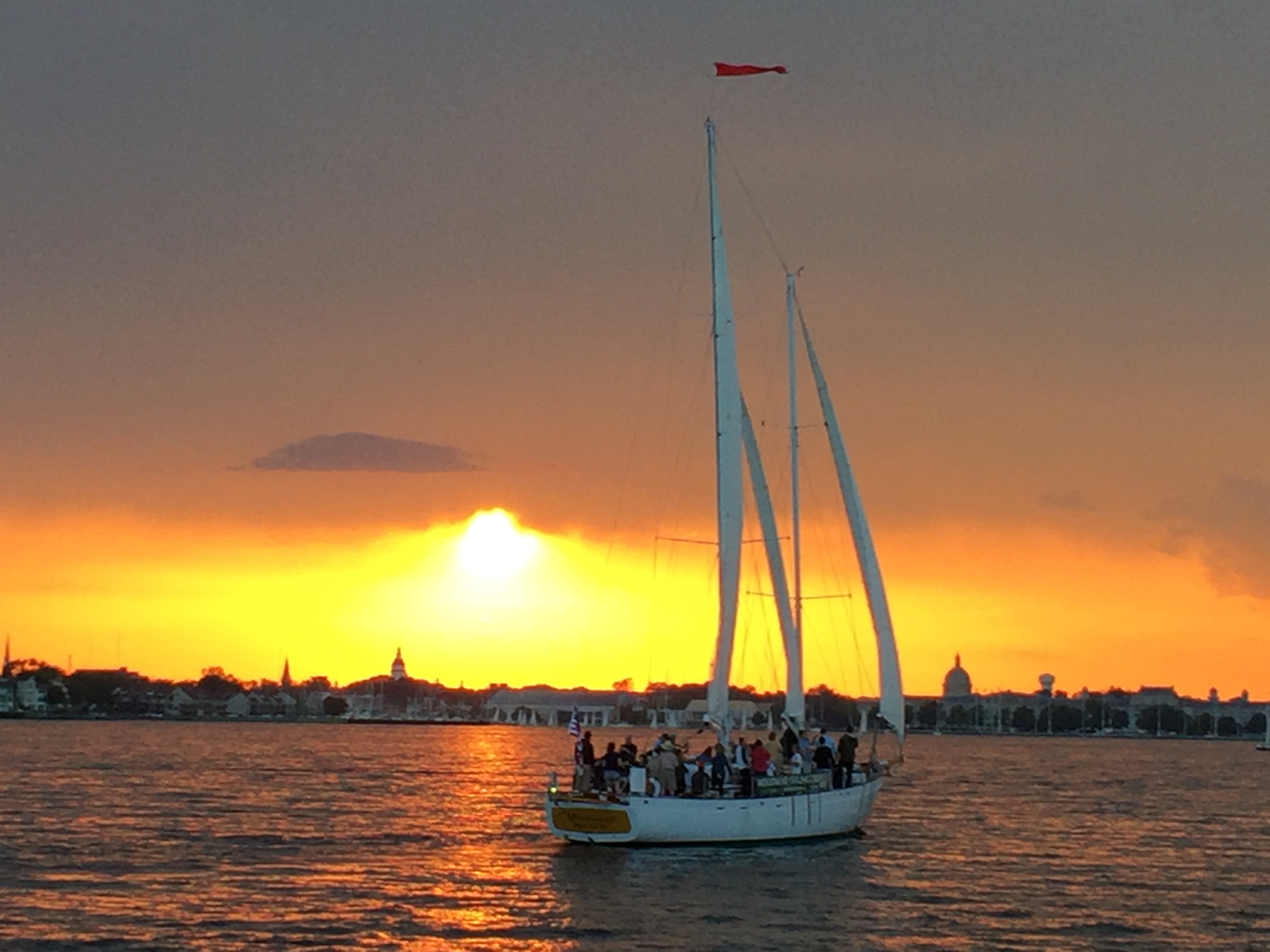 Schooner sailing into big yellow sunset over Annapolis