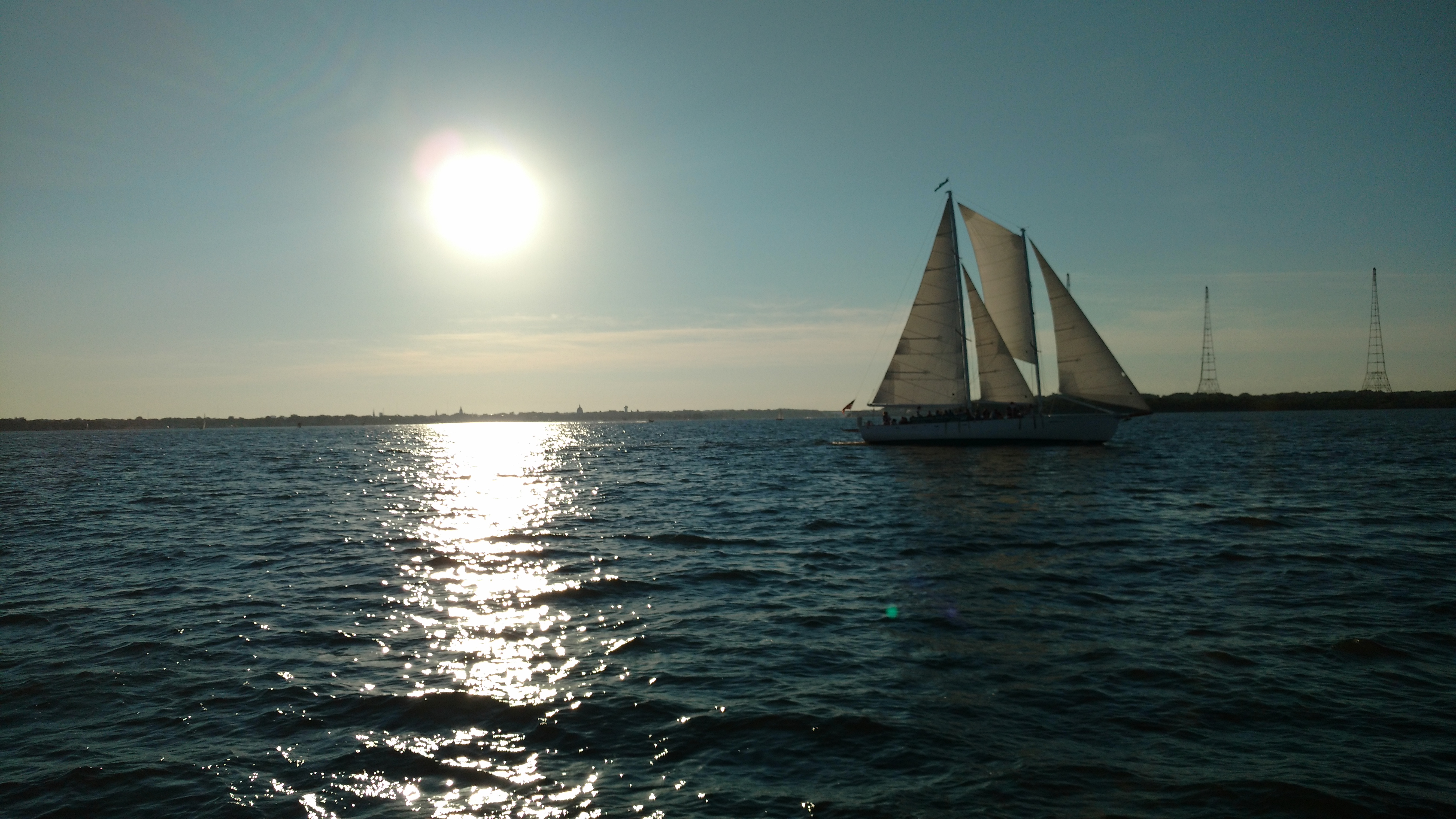 Schooner on an evening sail with bright sun reflecting on the water