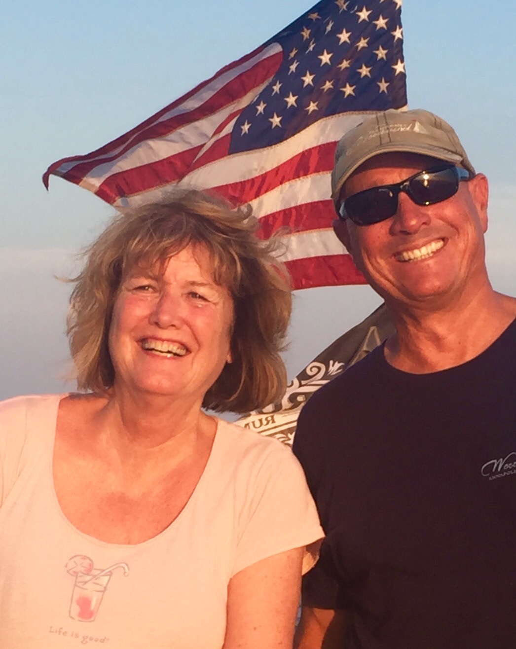 Captain sharing the joy of sailing with a guest and both are smiling!