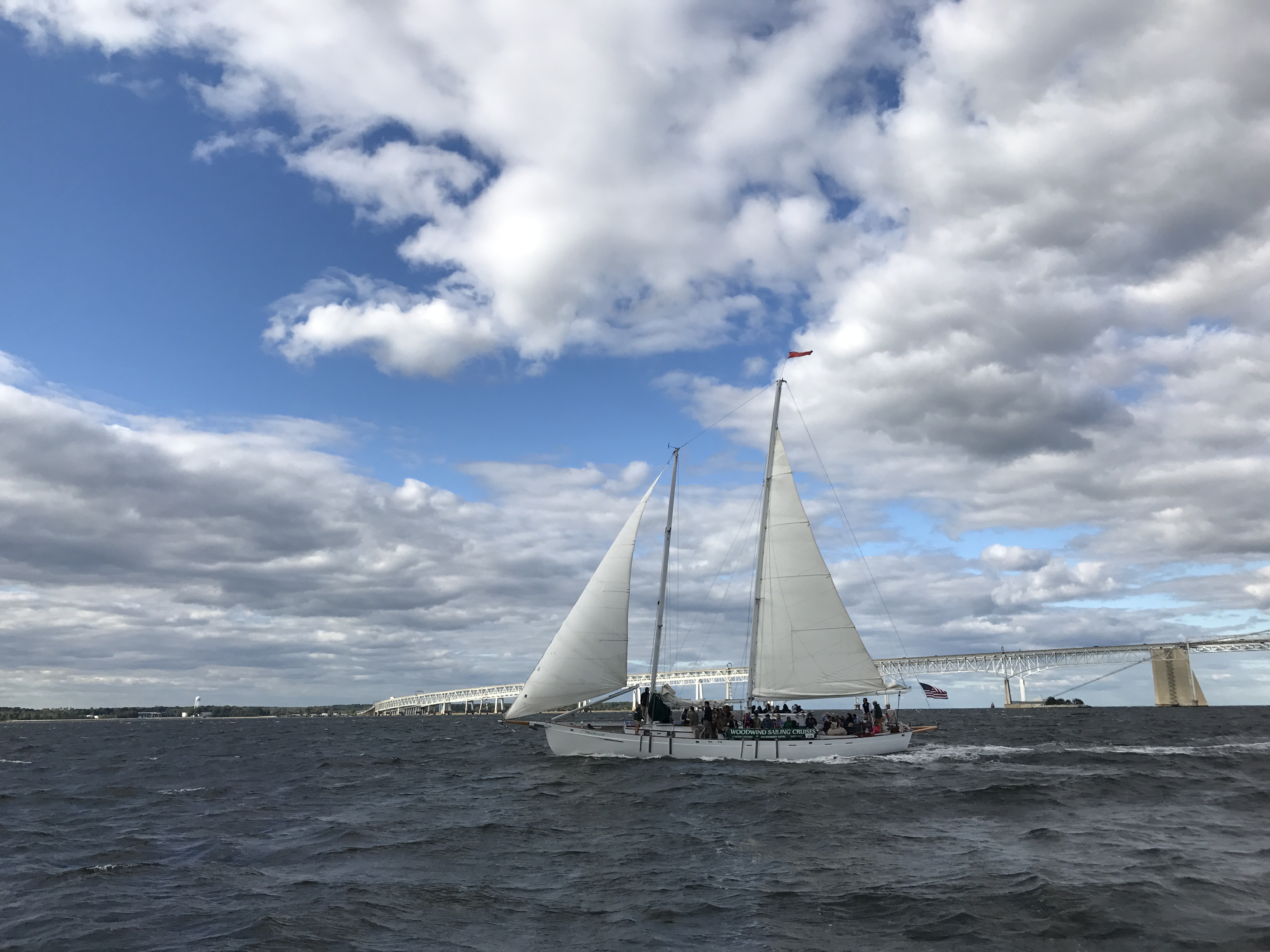 Schooner flying by the Bay Bridge on a blue sky windy day