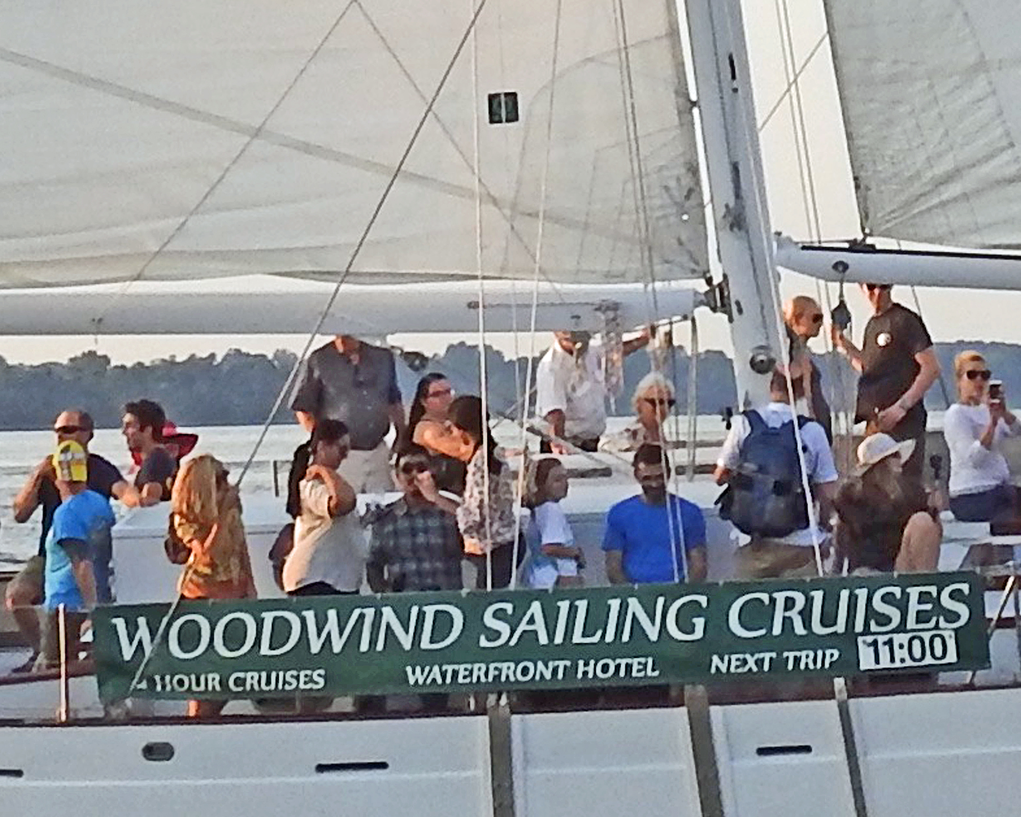 Woodwind Sailing Cruises banner on the side of schooner with guests