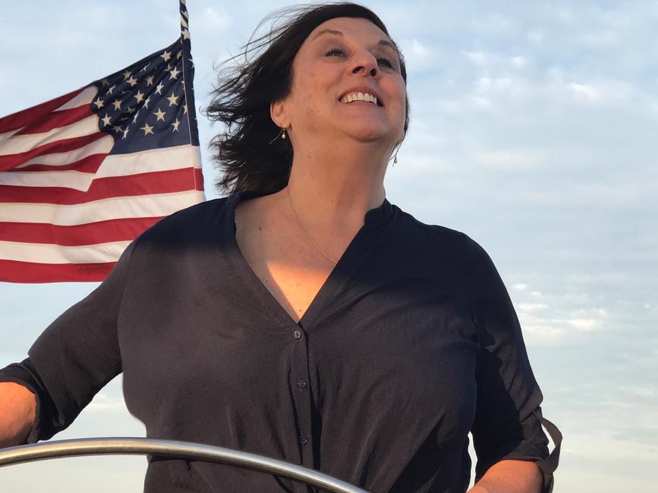 Women guest captaining the helm with American flag flying