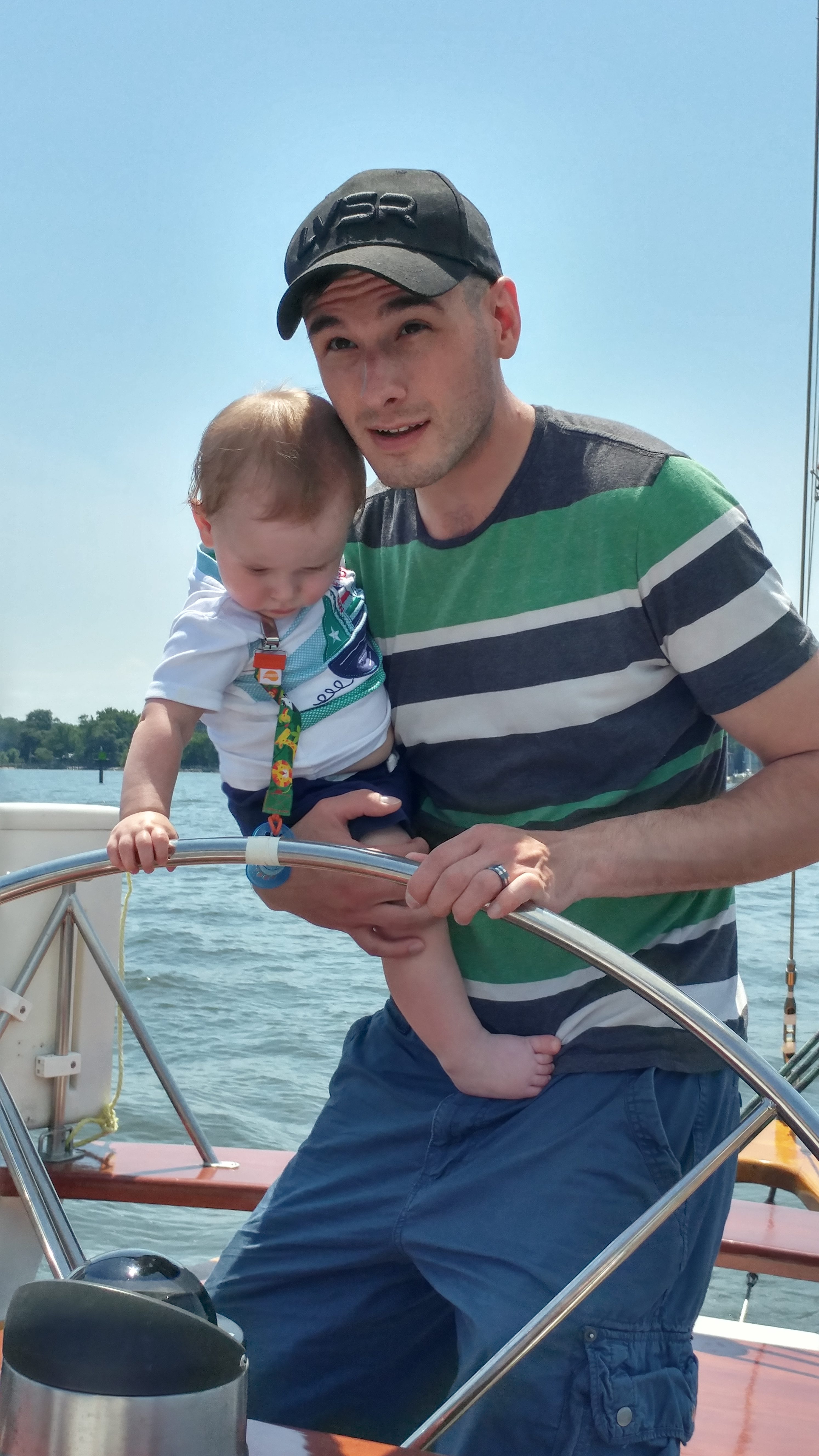 Man and baby steering boat