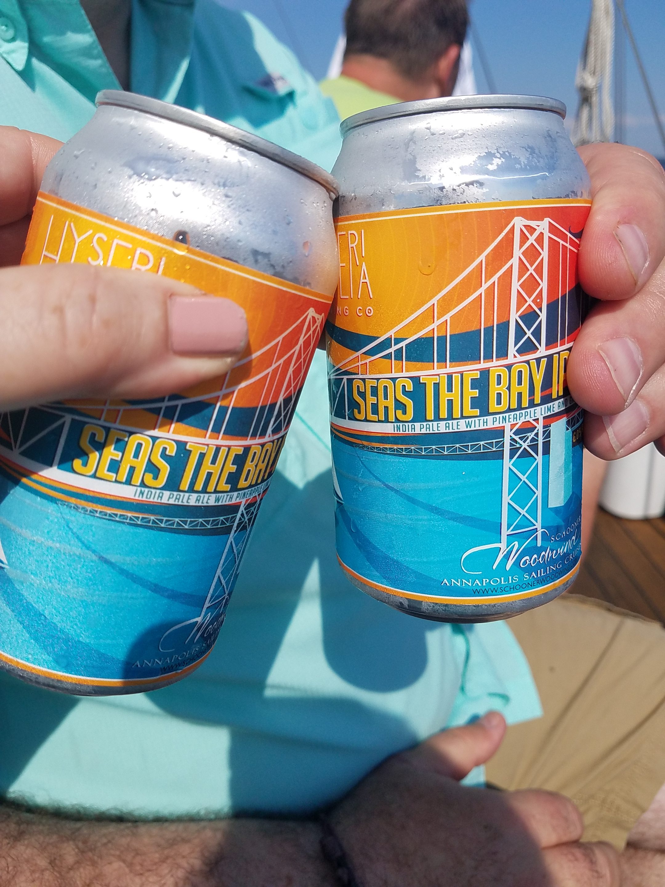 Two cold cans of Seas the Bay IPA cheers