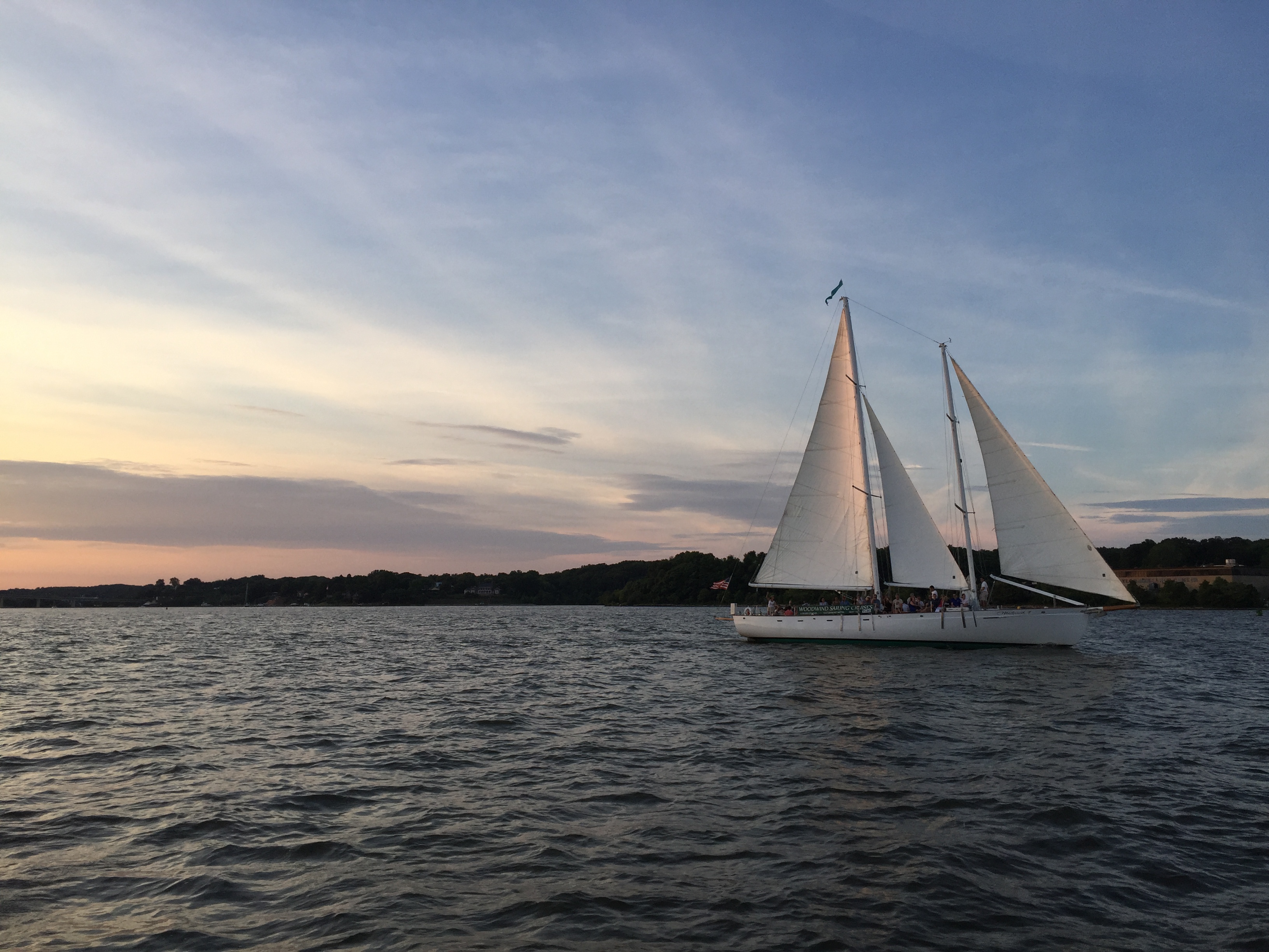 Schooner sailing on a quiet night at dusk along the shoreline