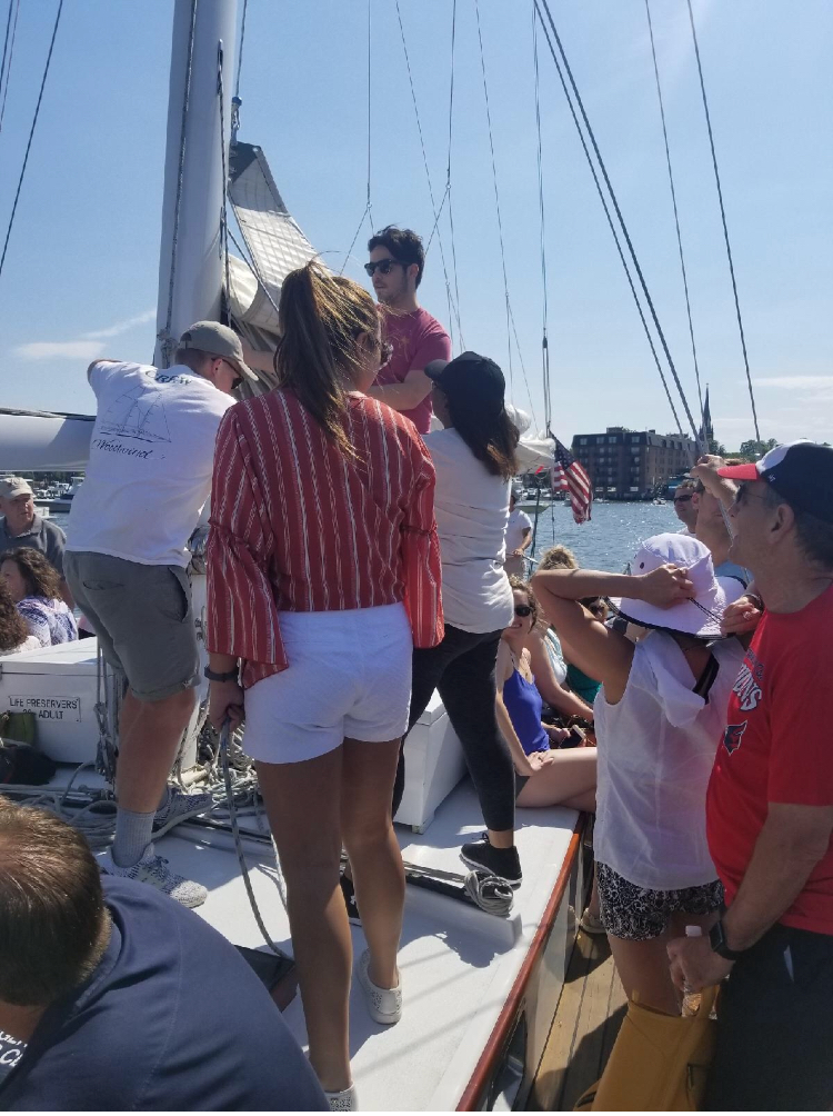 Group of guests learning how to raise the sails