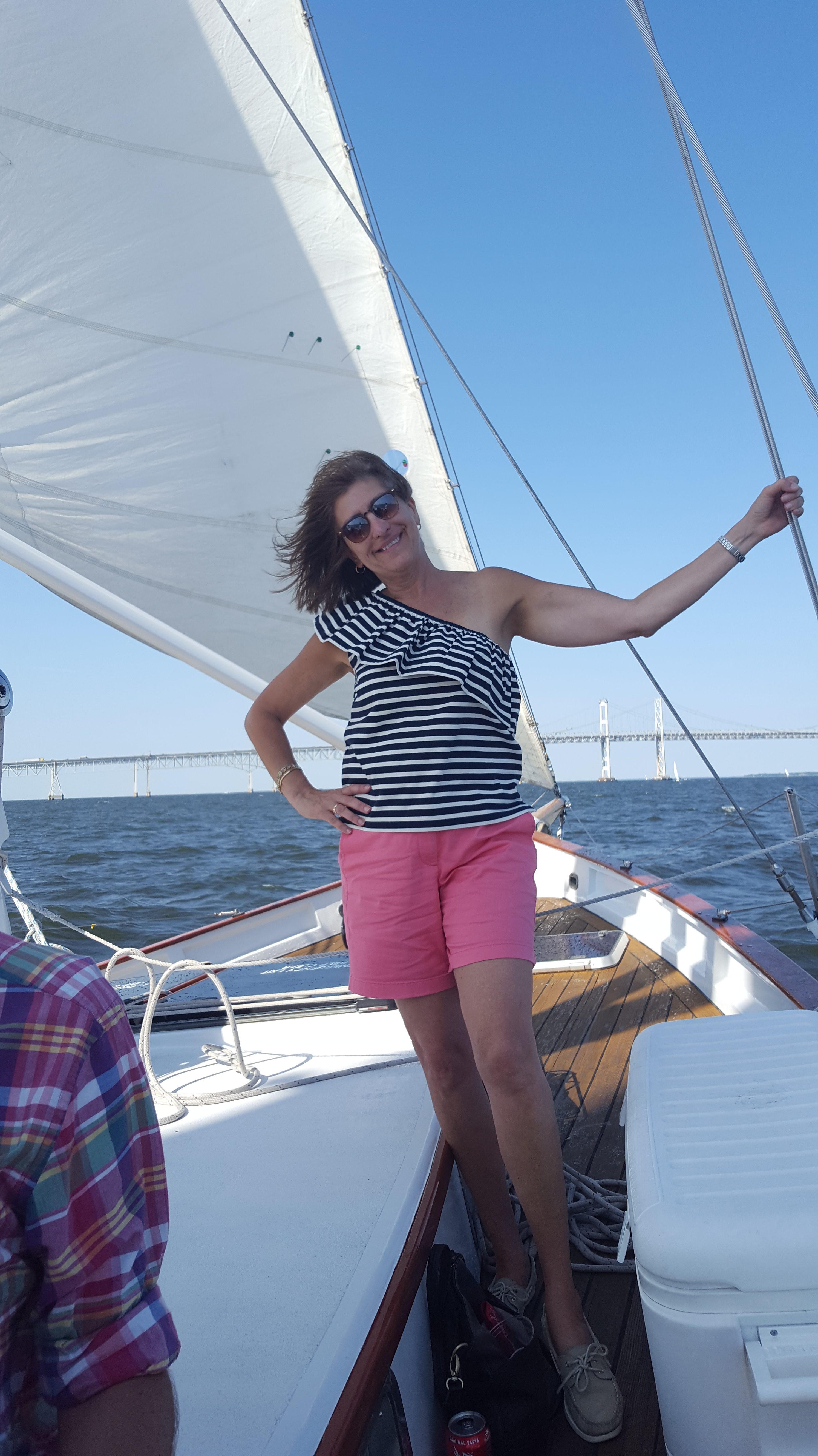 Women in pink shorts and striped shirt holding onto lines smiling