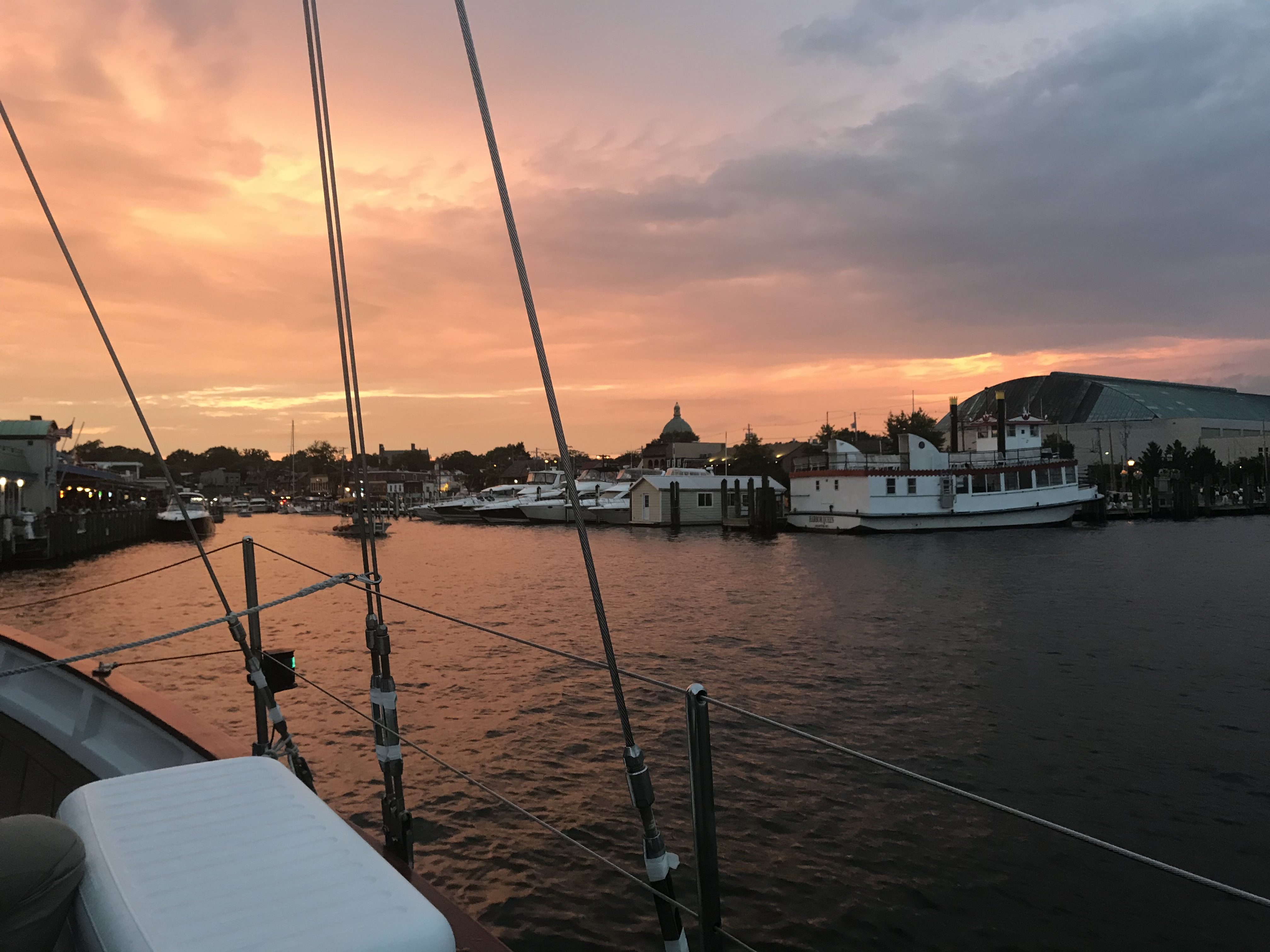 Boat coming into Annapolis Harbor with warm sunset all around