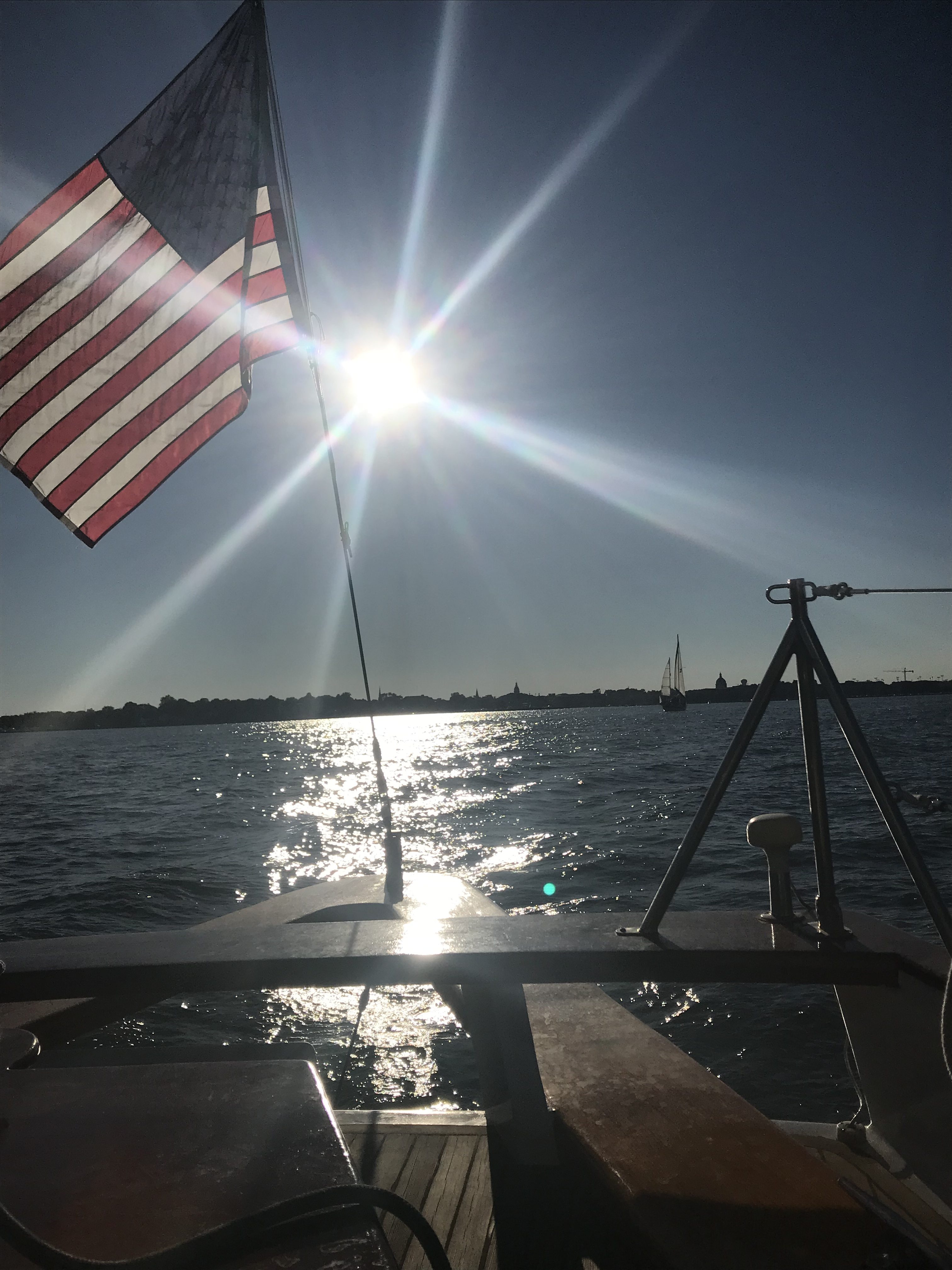 On board schooner with bright sun shining through American Flag