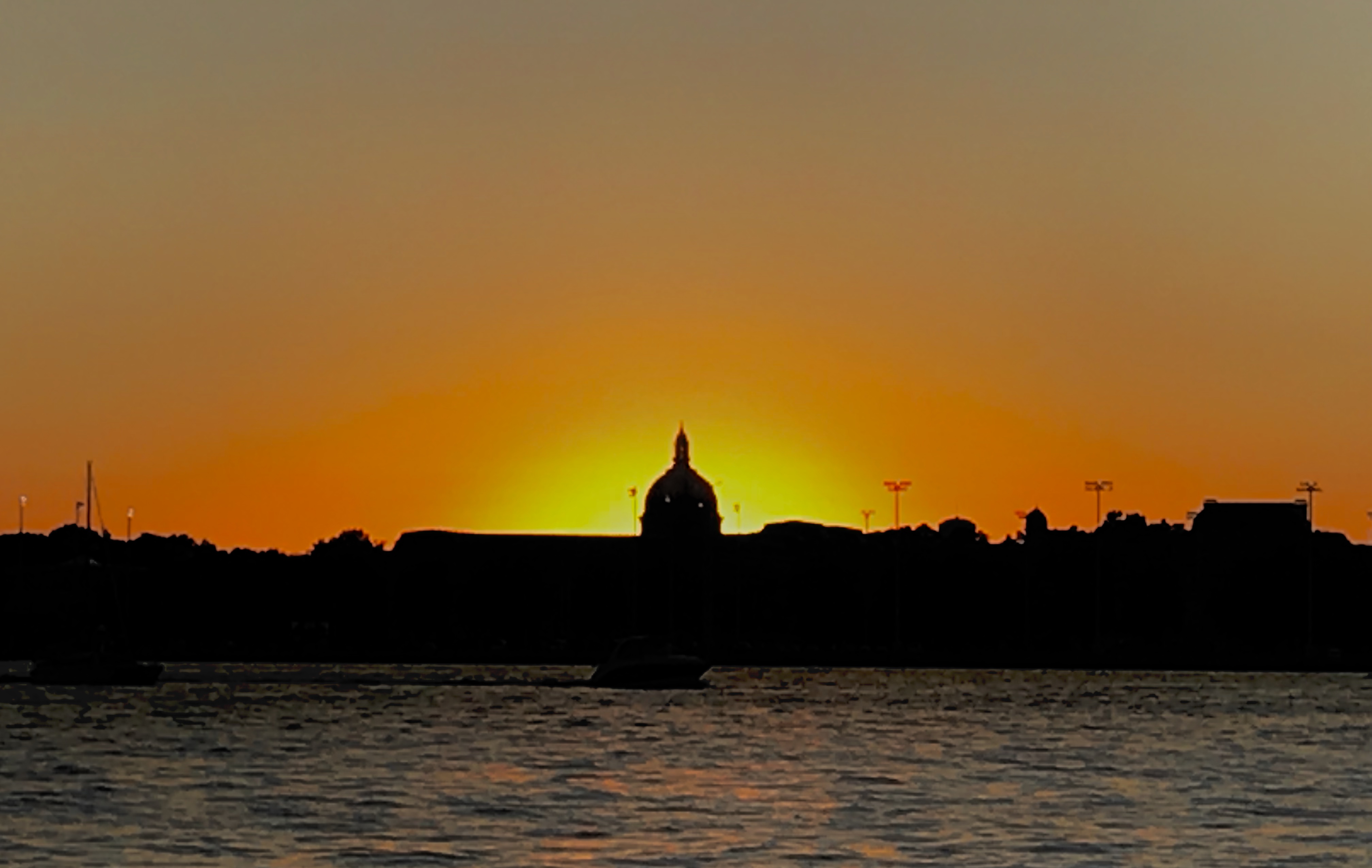 Sunset glowing bright orange behind the USNA Chapel skyline