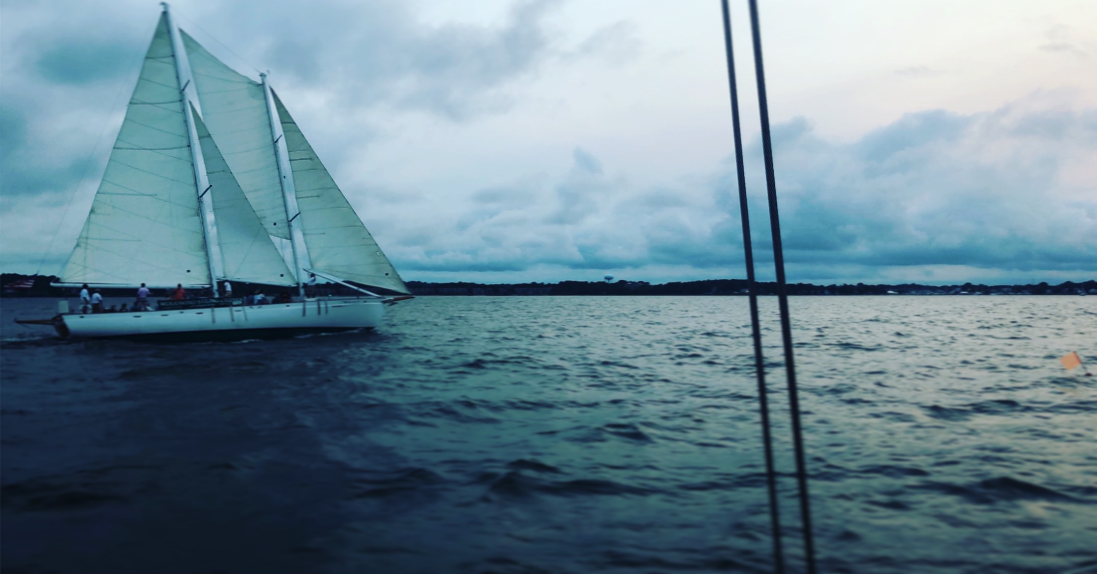 Schooner sailing through cool dark blue cloudy day