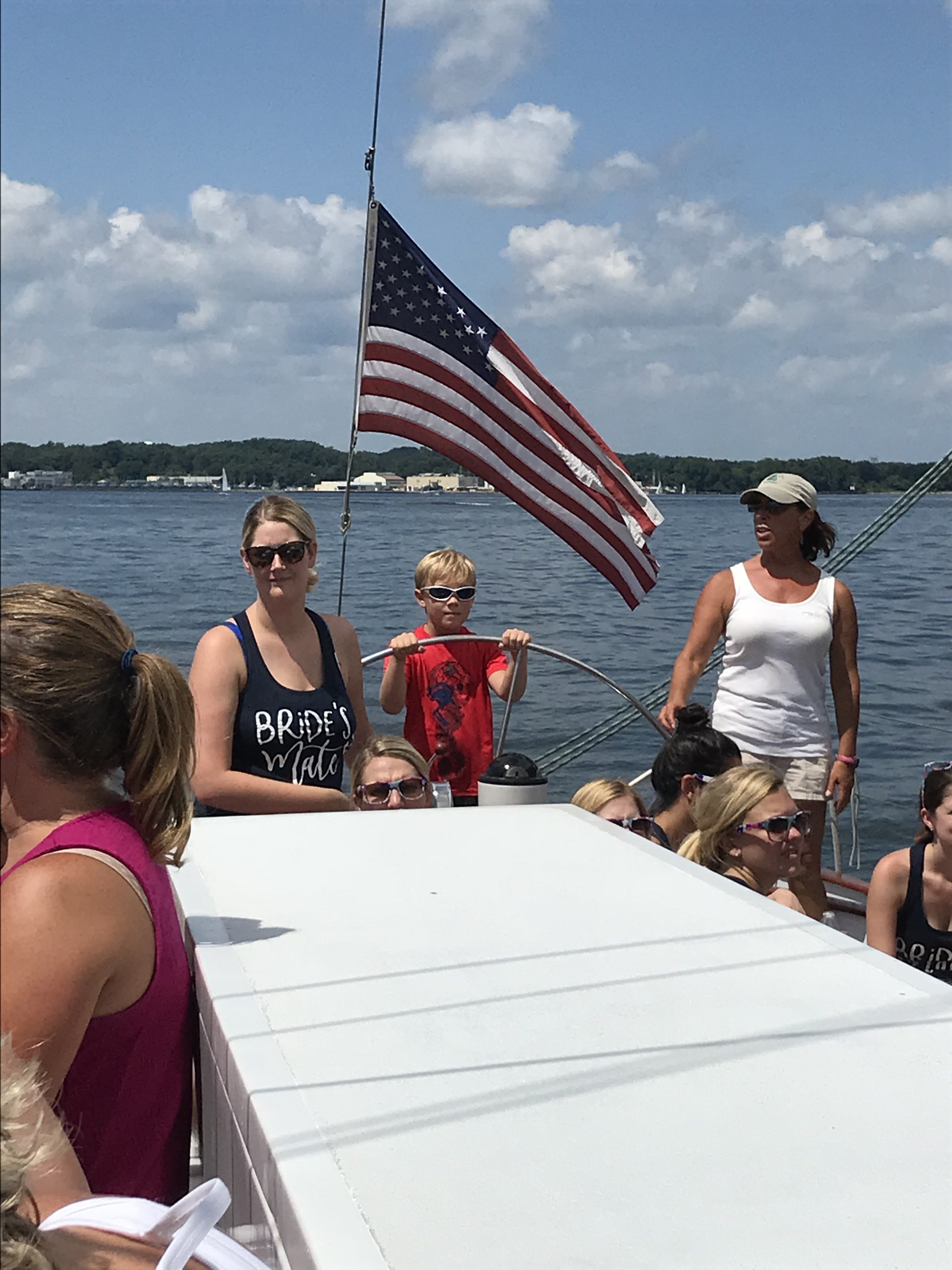 Young boy steering the boat with captains guidance