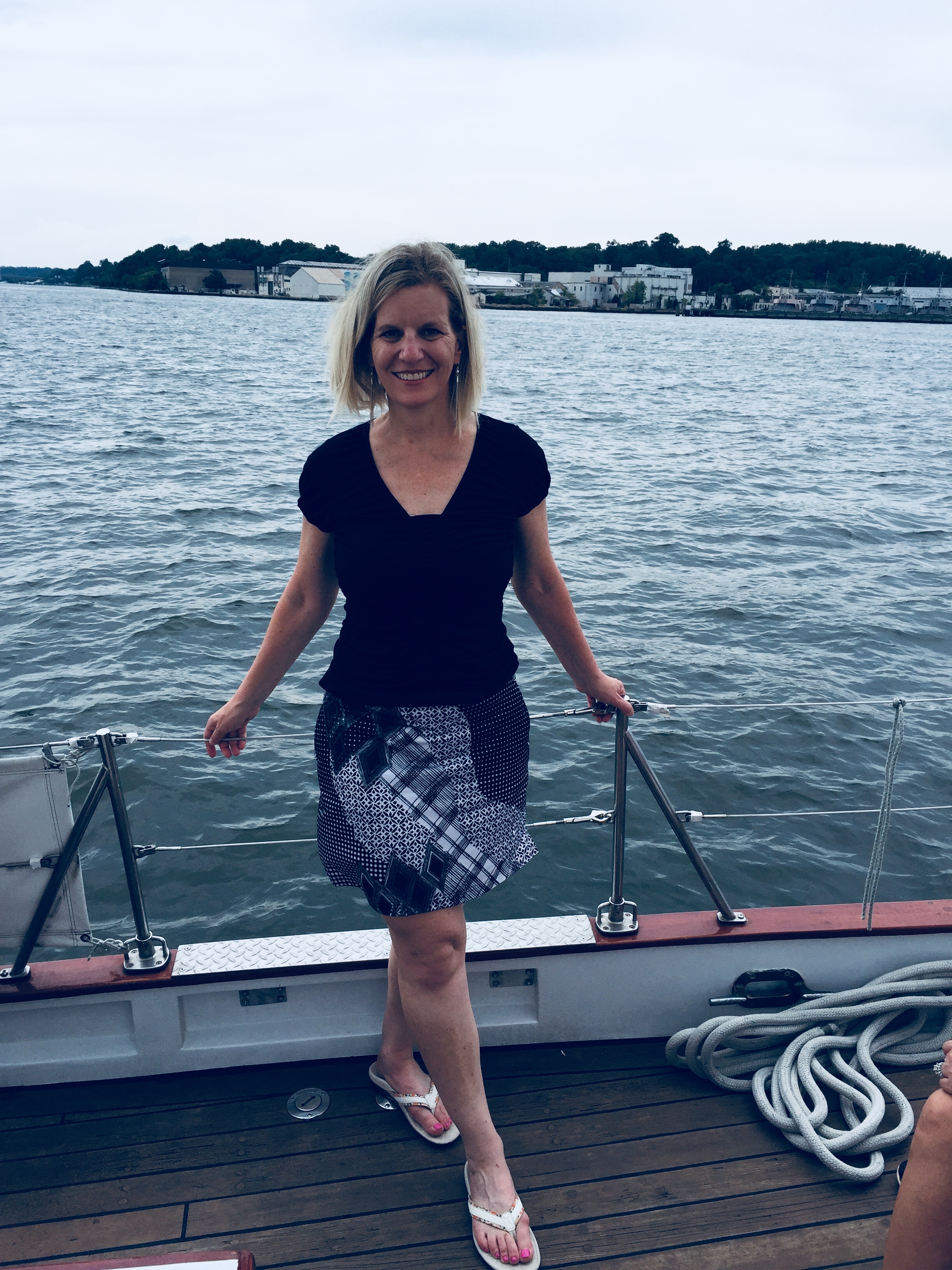 Women smiling and posing on deck looking out at water